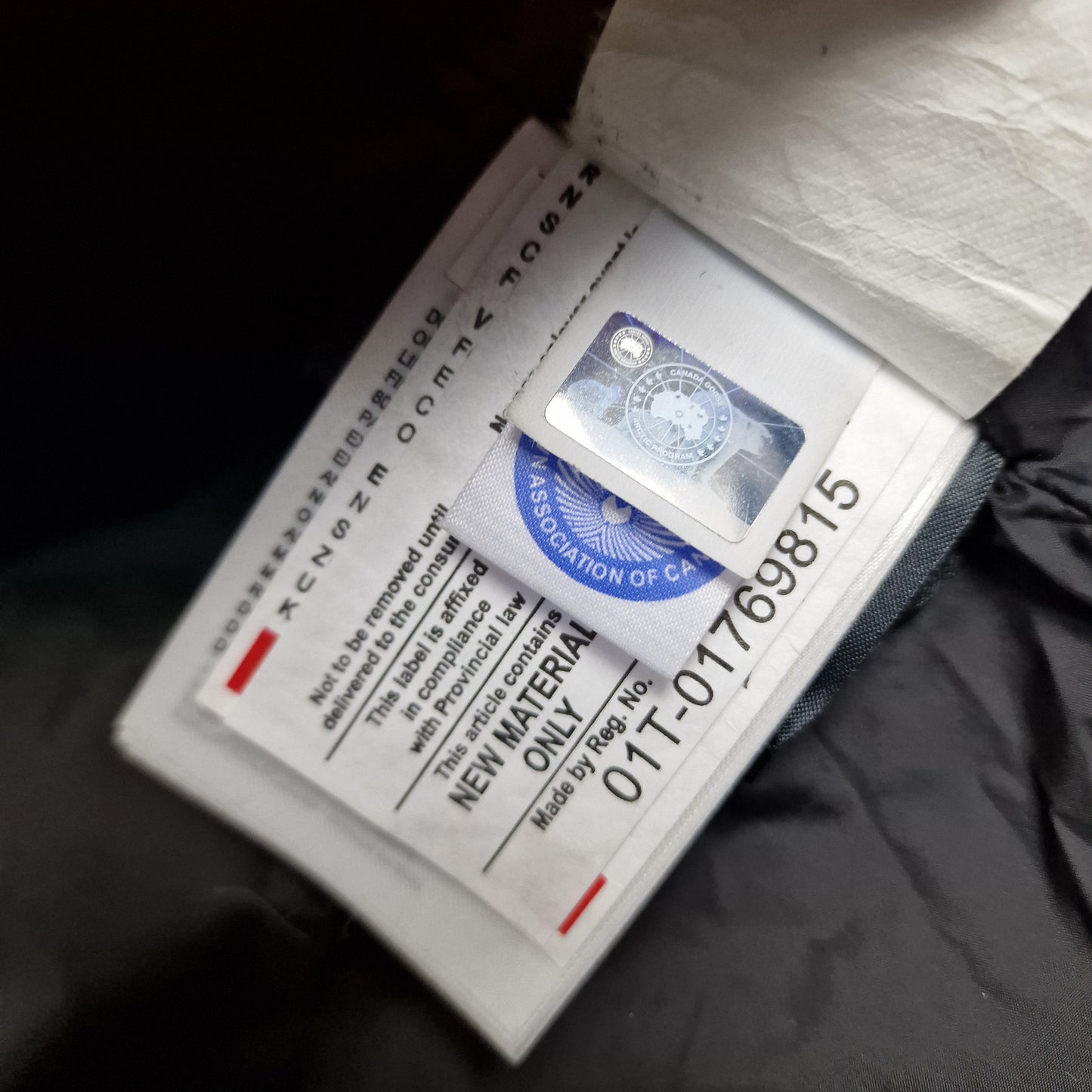 Close-up of Canada Goose authenticity hologram on Carson Parka 3805MA, verification label confirming genuine men's Small navy luxury winter coat