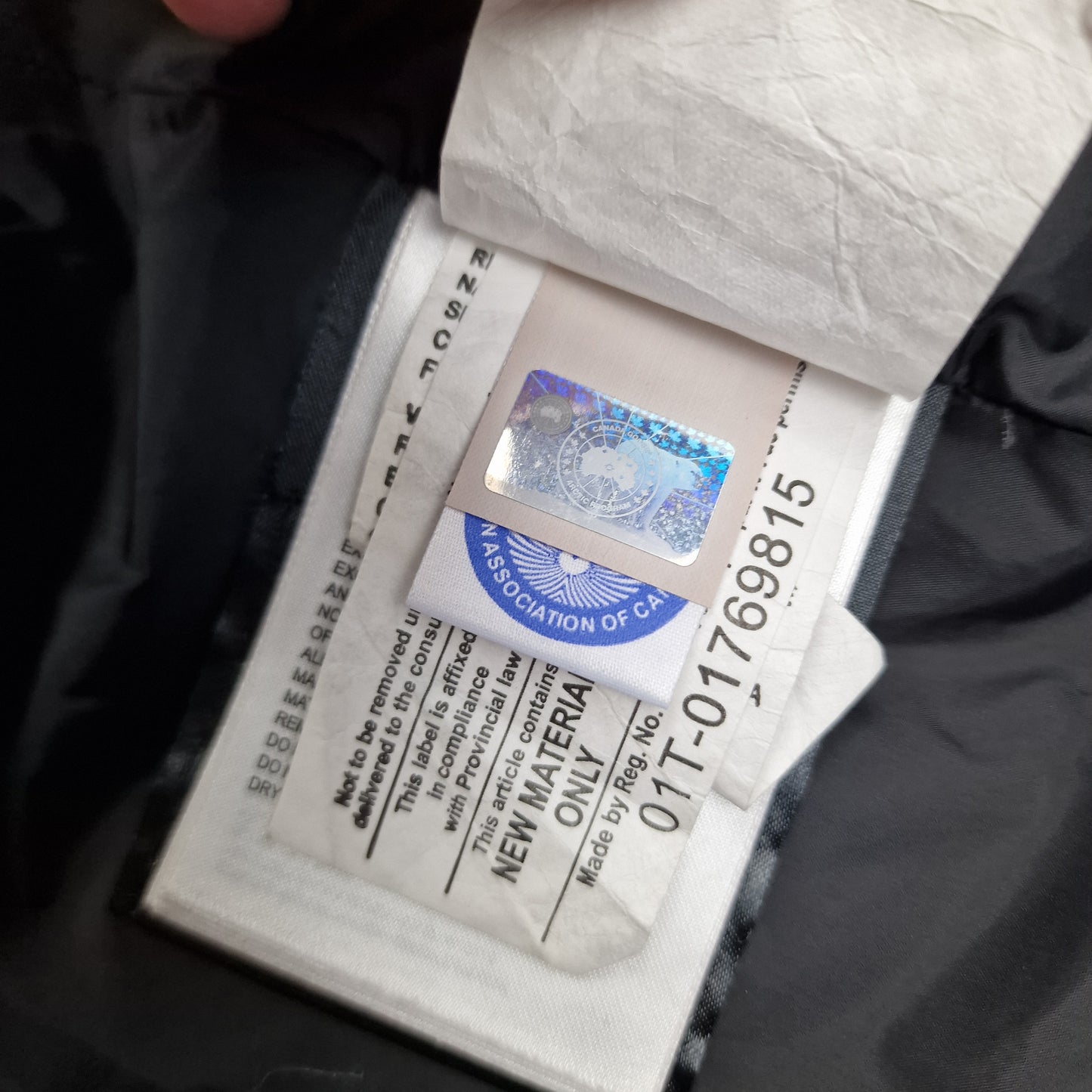 Close-up of Canada Goose authenticity hologram on Shelburne Parka 3802L, verification label confirming genuine Purple Arctic Disk women's luxury winter coat