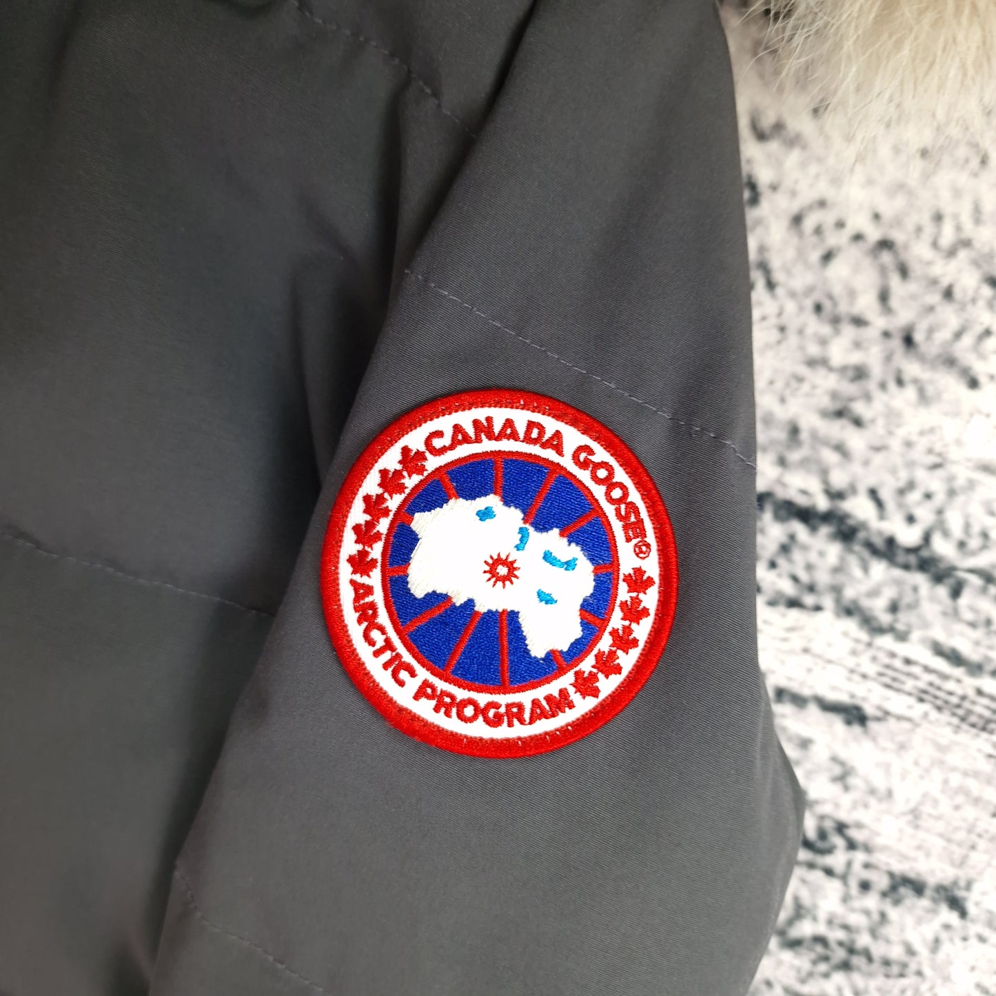 Close-up of authentic Canada Goose Arctic Program badge on Mackenzie Parka, Graphite grey Medium, similar quality to Shelburne Parka women's luxury winter jacket