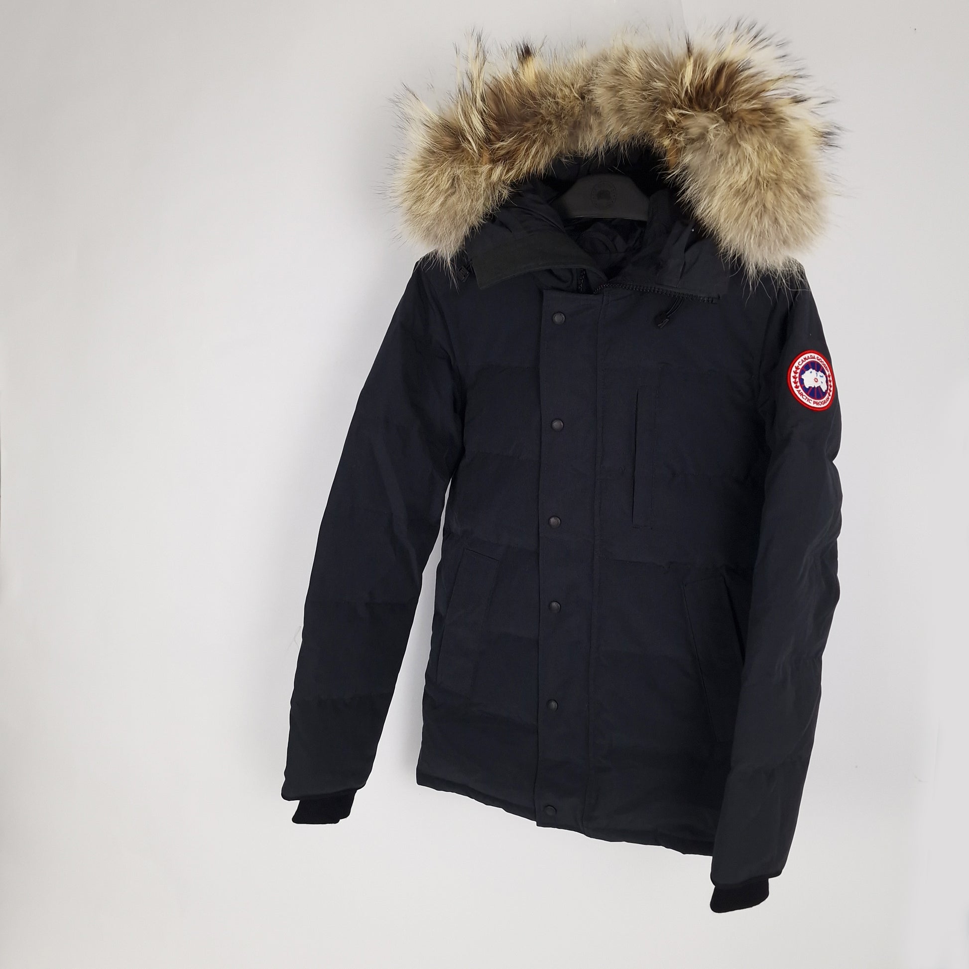 Angled view of Canada Goose Carson Parka 3805MA men's small displaying fur hood, Arctic badge, and thigh-length coverage