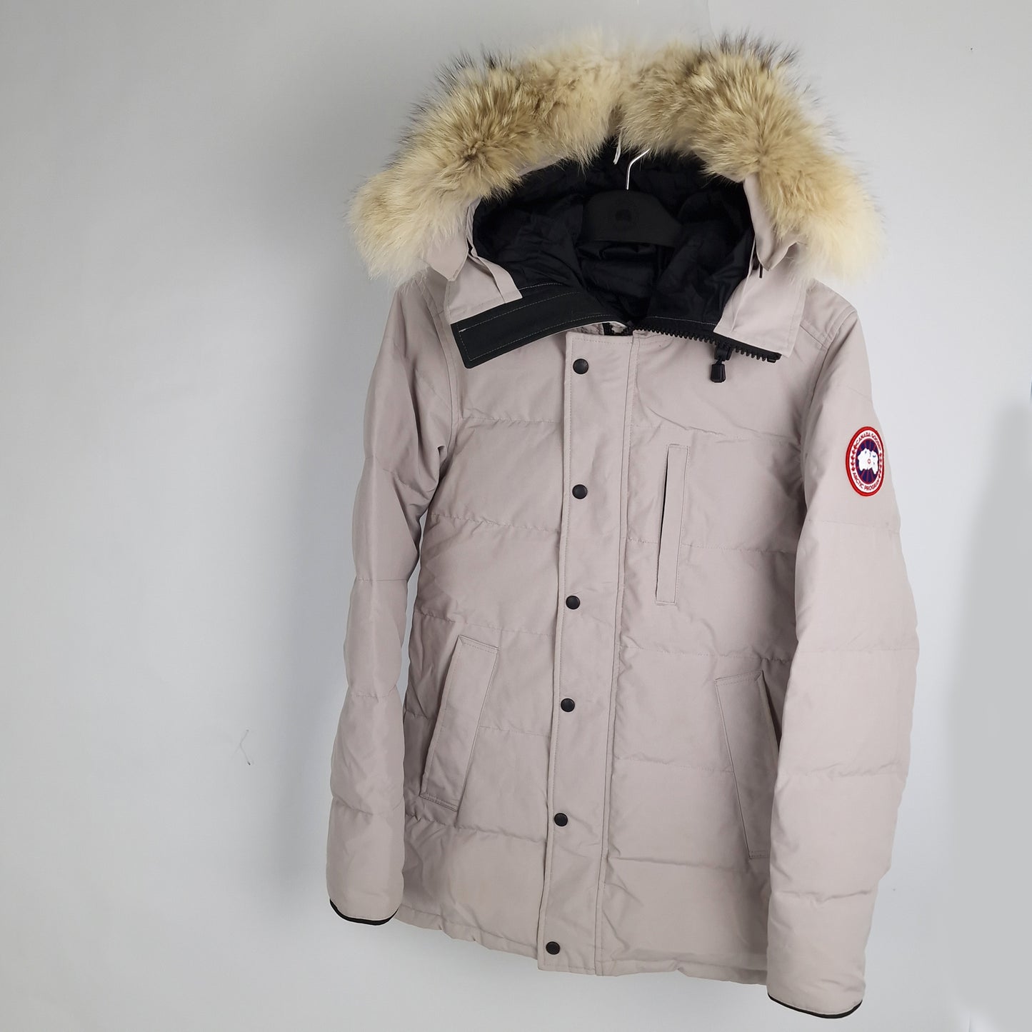 Angled view of Canada Goose Carson Parka 3805M men's small displaying coyote fur hood trim and premium limestone finish