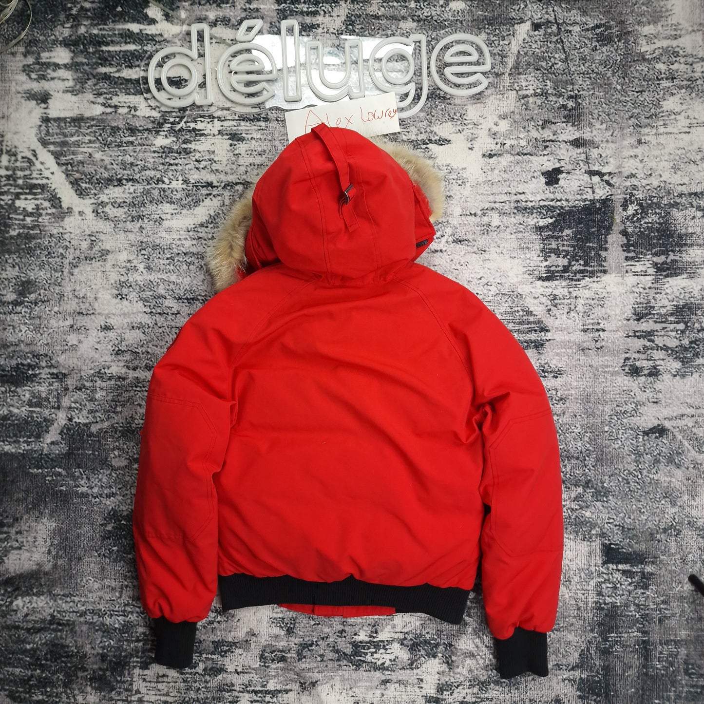 Back view flat lay of red Canada Goose Chilliwack bomber jacket size small showing fur-trimmed hood and black ribbed waistband