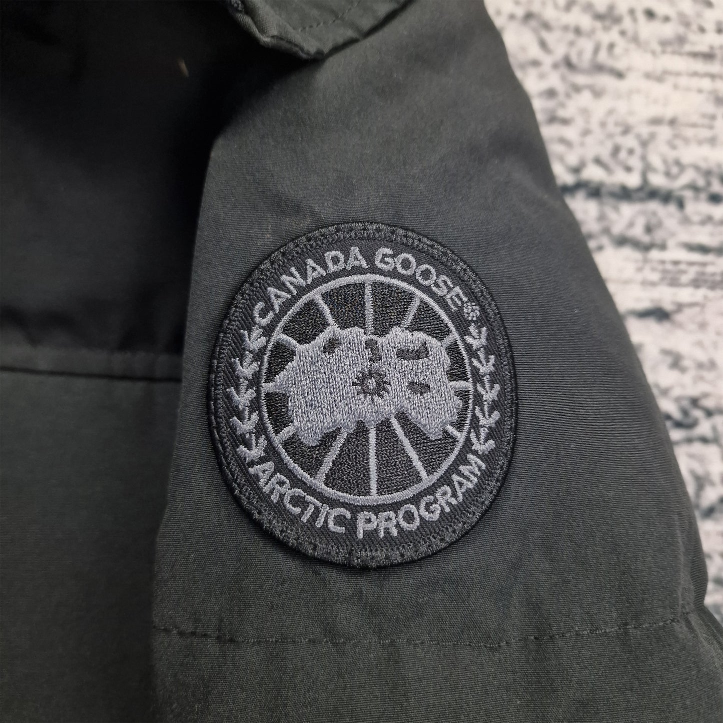 Close-up of exclusive black-on-black Canada Goose Arctic Program badge on Macmillan Black Label Parka sleeve