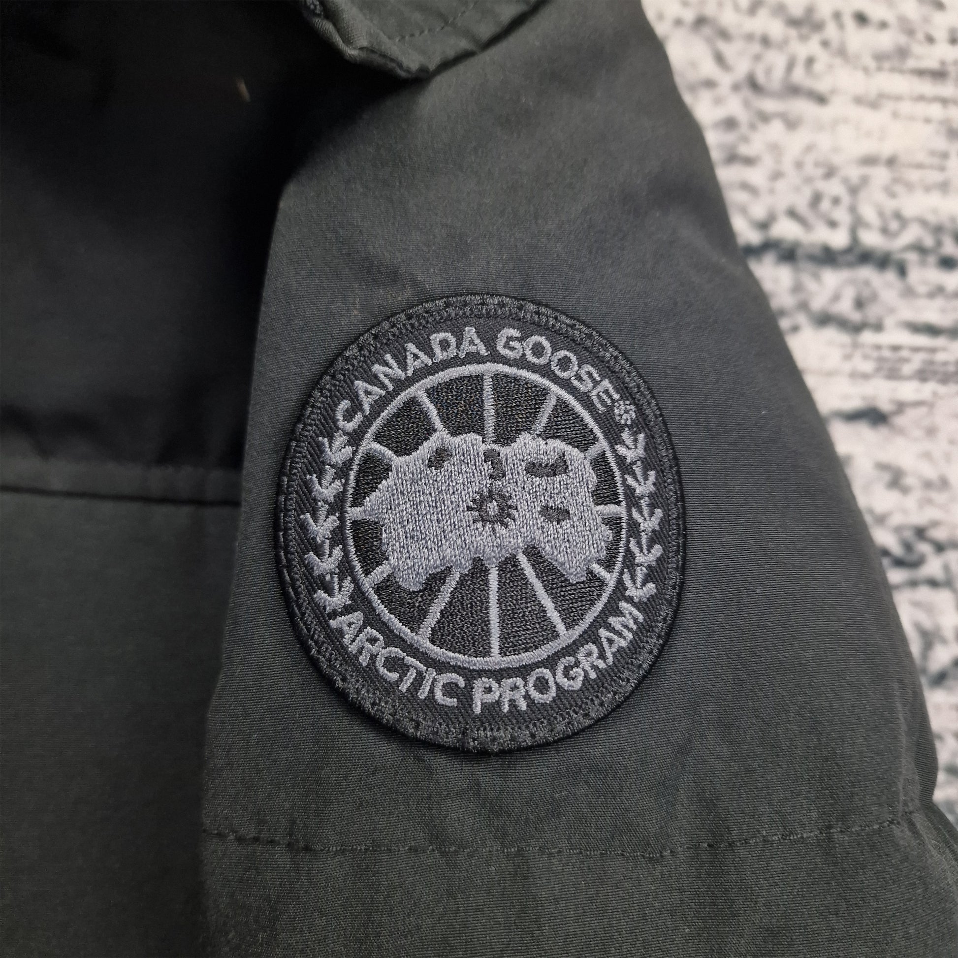 Close-up of exclusive black-on-black Canada Goose Arctic Program badge on Macmillan Black Label Parka sleeve