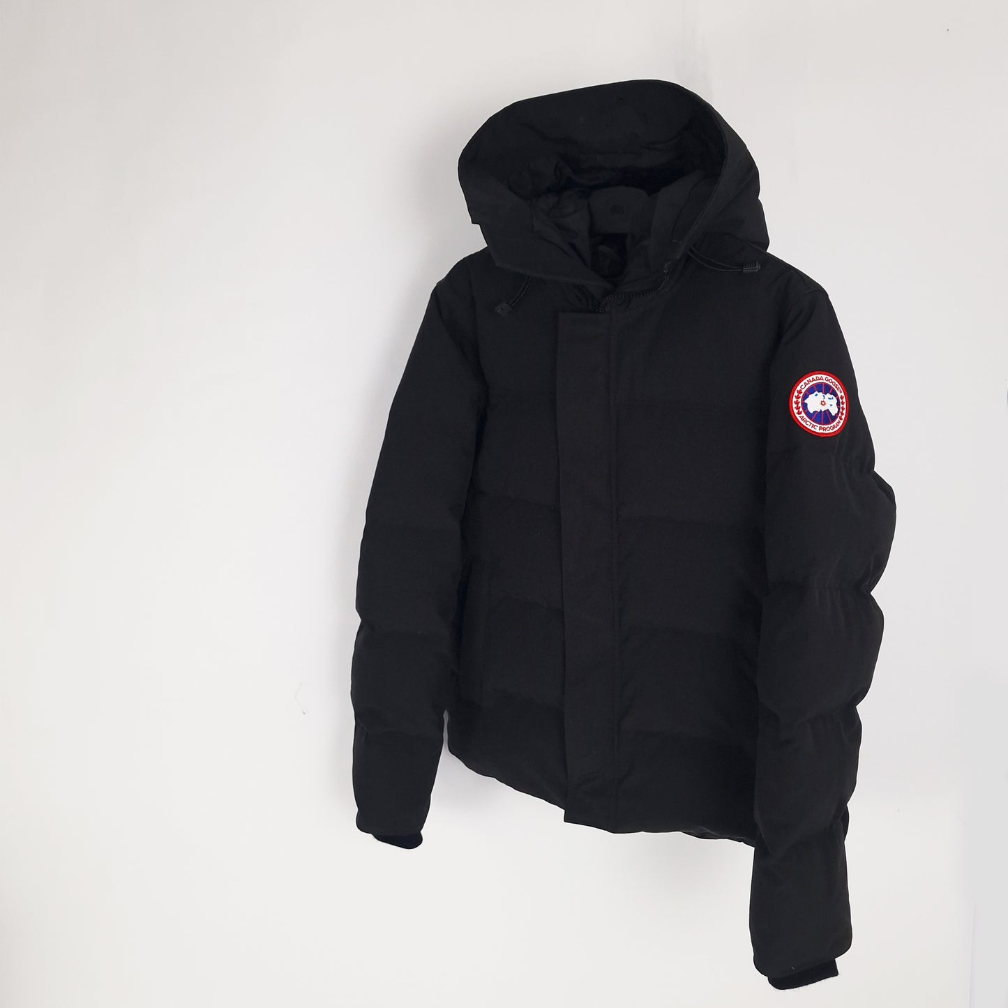 Angled view of black Canada Goose Macmillan Parka 3804MA men's large showing ribbed cuffs and Arctic Program badge