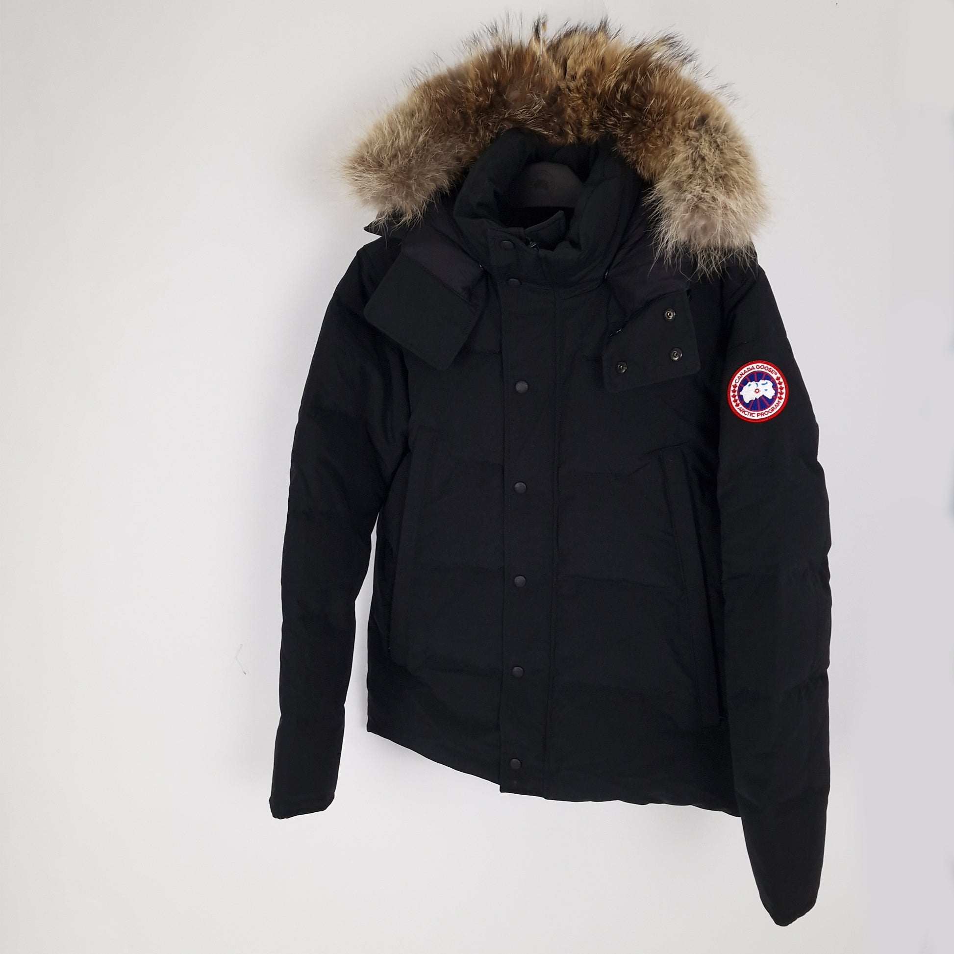 Three-quarter view of Canada Goose Wyndham Heritage jacket 3808MA in black, size large, displaying coyote fur hood trim and Arctic Program patch