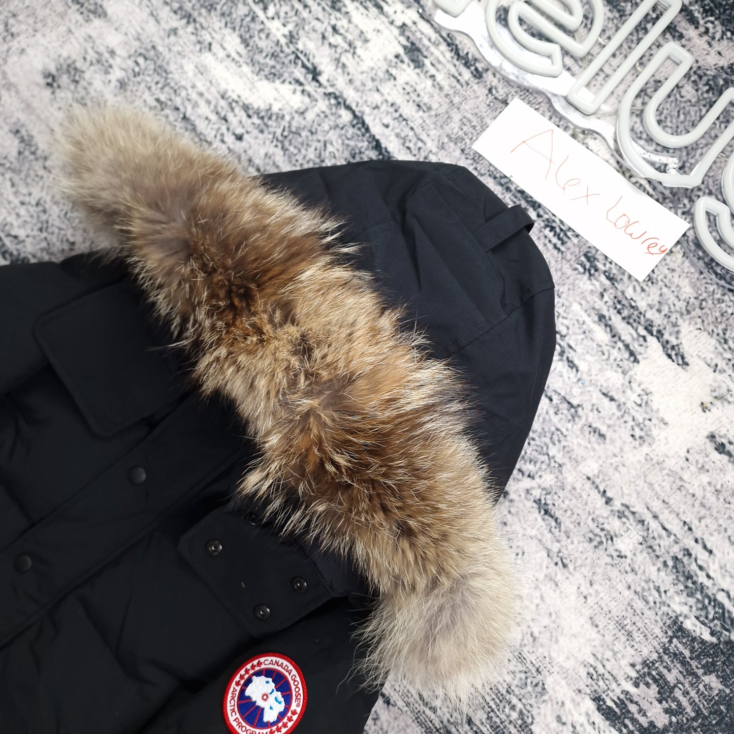 Close-up of Canada Goose Wyndham Heritage parka 3808MA men's large in black, showcasing premium coyote fur hood trim and signature Arctic Program badge