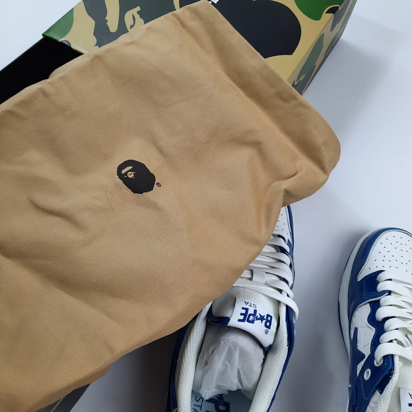 A Bathing Ape Bapesta sneakers with beige BAPE dust bag featuring ape head logo, complete packaging UK8