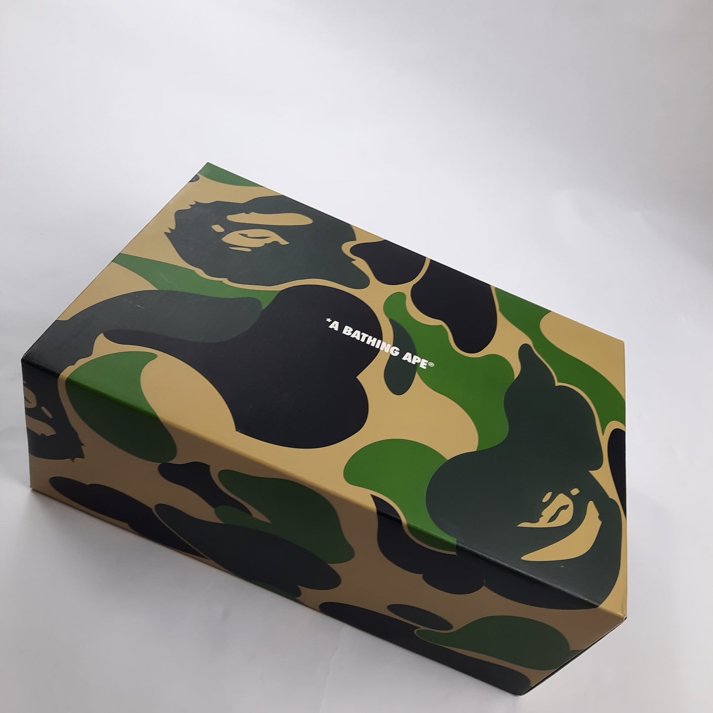 Top view of A Bathing Ape shoe box in signature camo pattern, authentic BAPE Bapesta packaging with logo