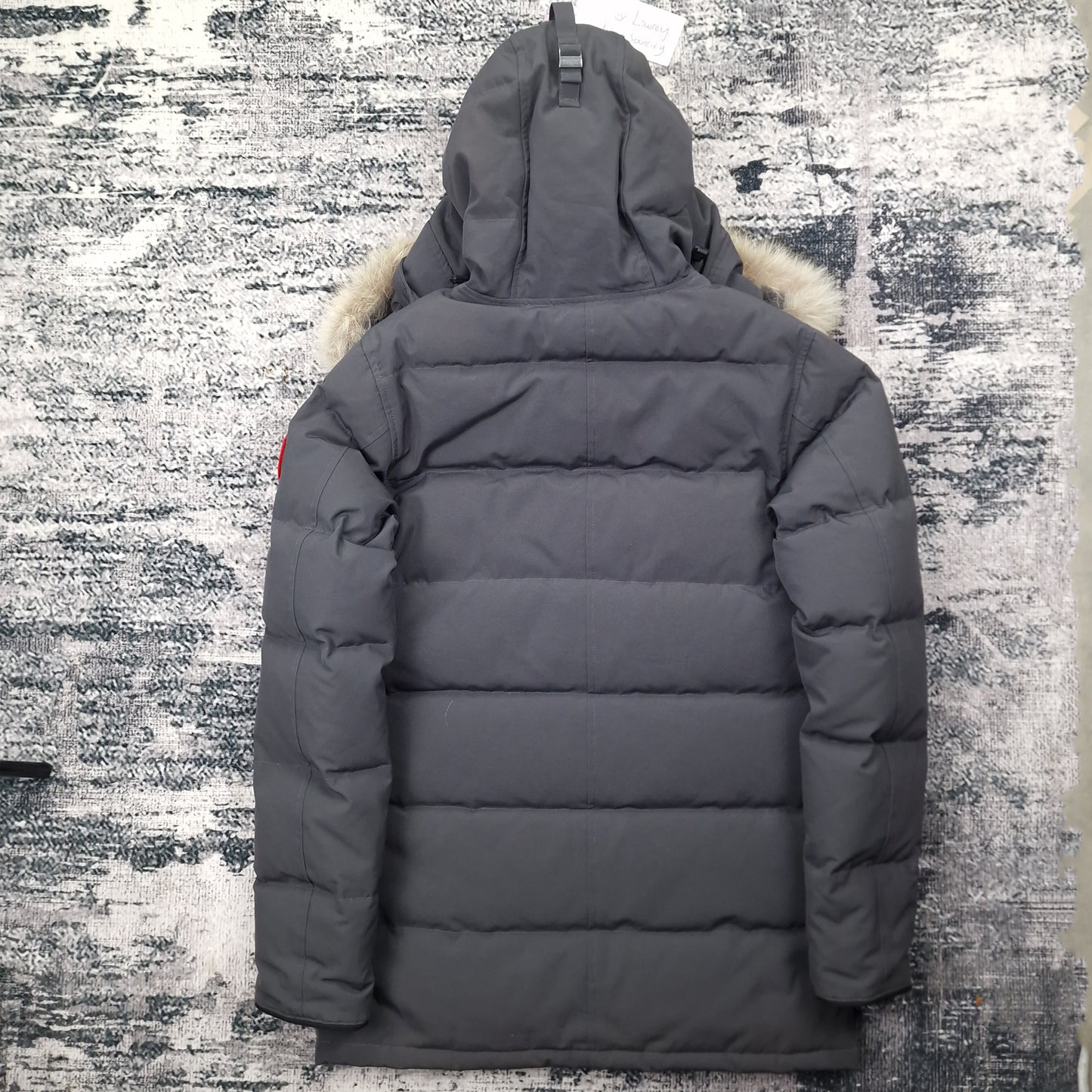 Back view of men's Canada Goose Carson Parka 3805M Small in Graphite grey featuring Arctic Program patch, hip-length winter coat photographed on styled background
