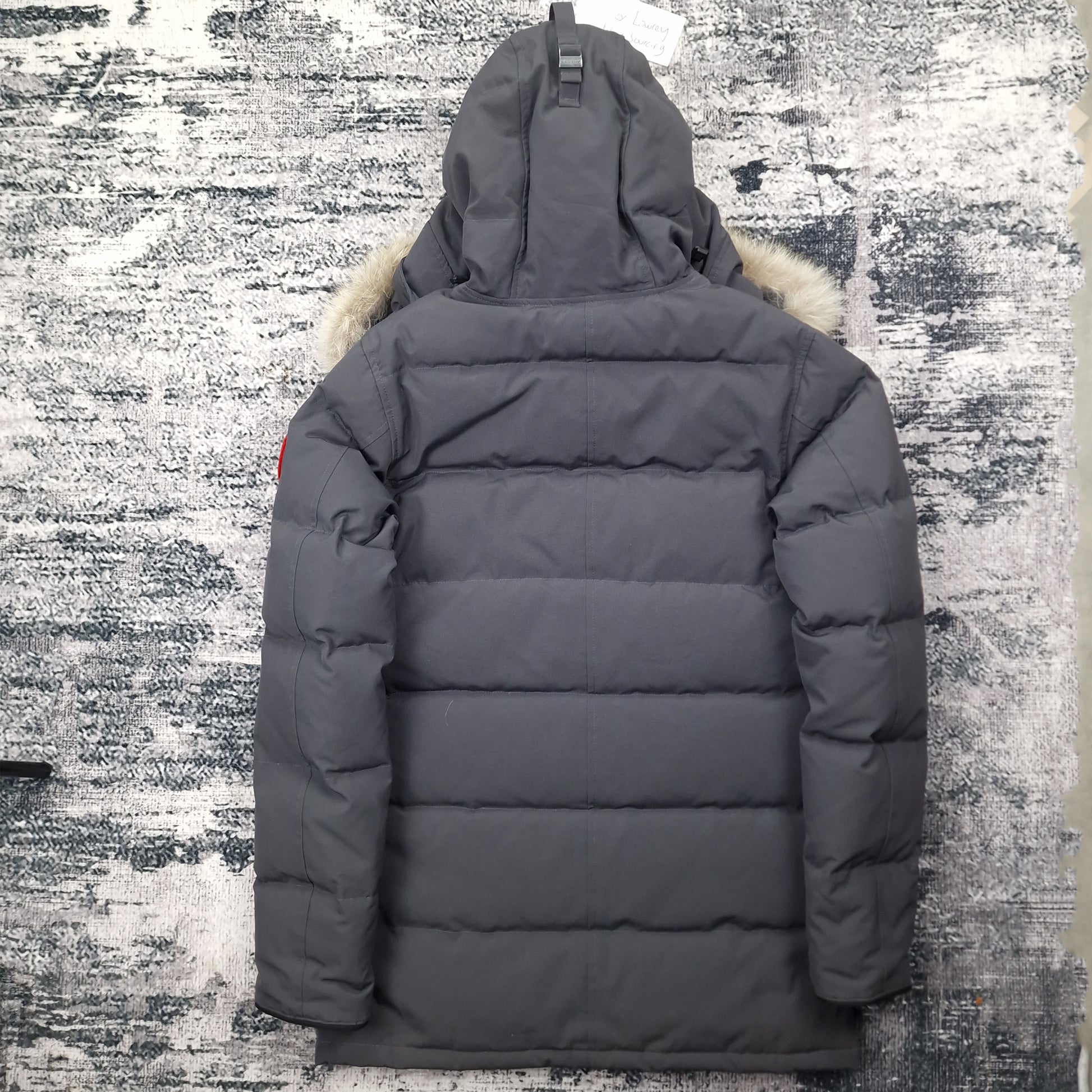 Back view of men's Canada Goose Carson Parka 3805M Small in Graphite grey featuring Arctic Program patch, hip-length winter coat photographed on styled background