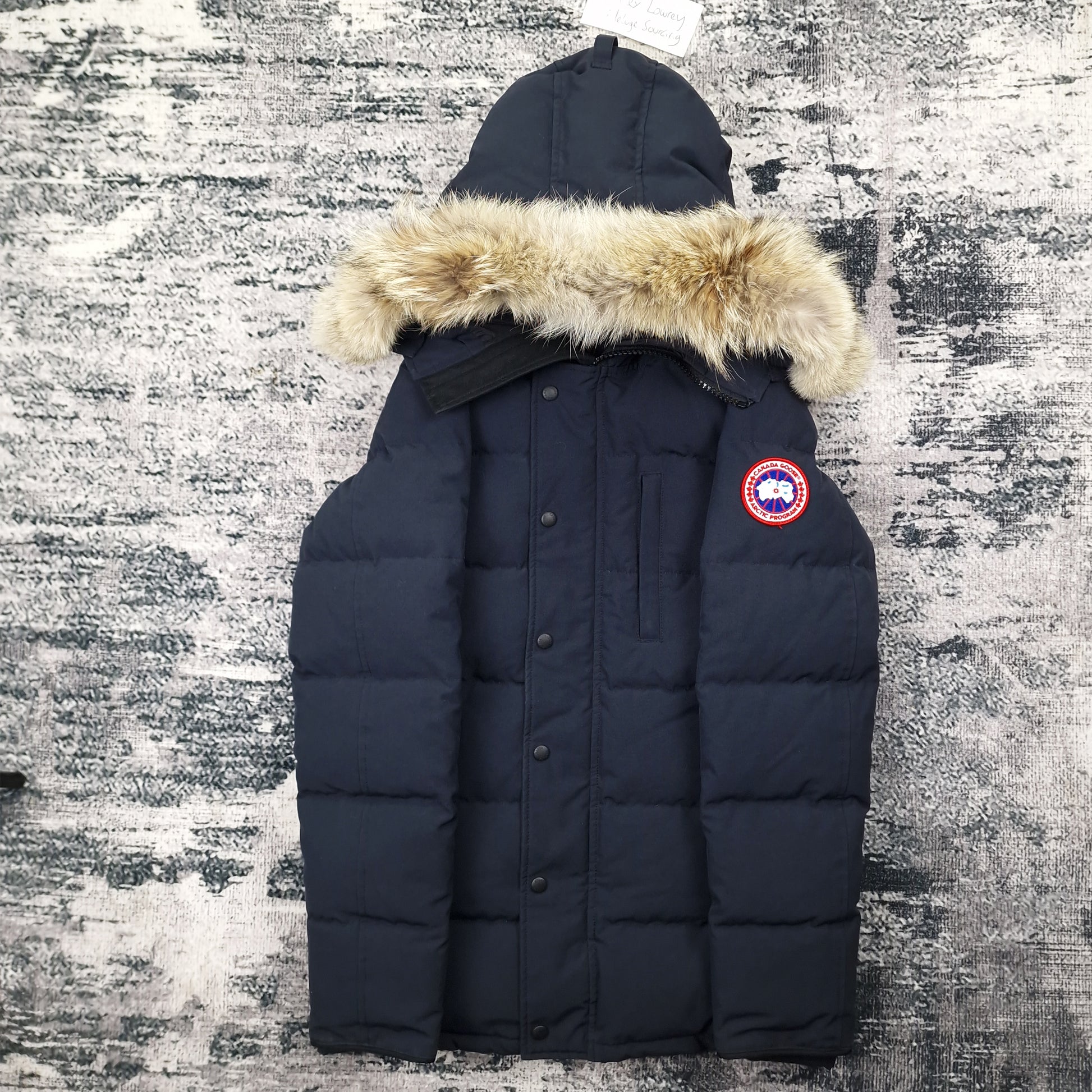 Front view of men's Canada Goose Carson Parka 3805MA Small in navy with coyote fur-trimmed hood, luxury winter coat photographed on styled background