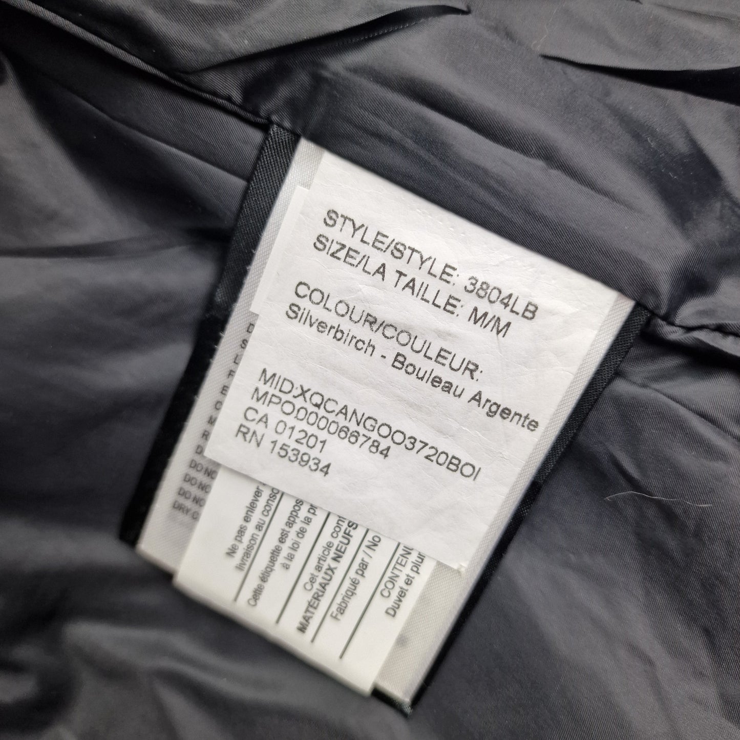 White care label washtag showing style code 3804LB, Black Label Silverbirch color designation, and size Medium information for authentic Canada Goose Chelsea Parka women's winter jacket