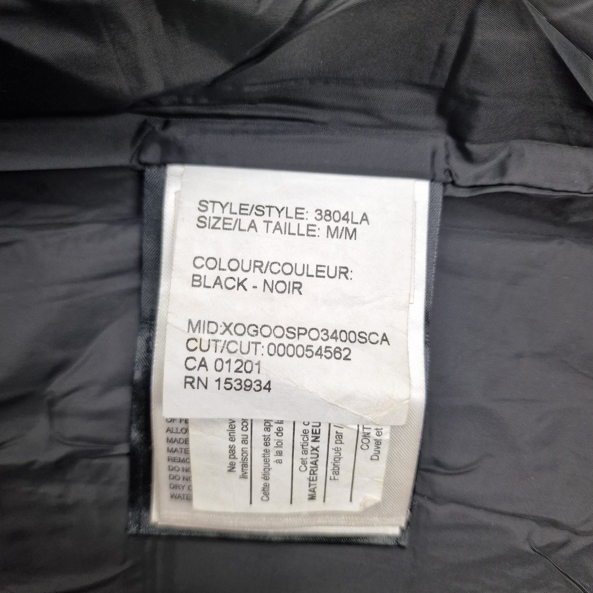 White care label washtag showing style code 3804LA, black color designation, and size Medium information for authentic Canada Goose Chelsea Parka women's winter jacket