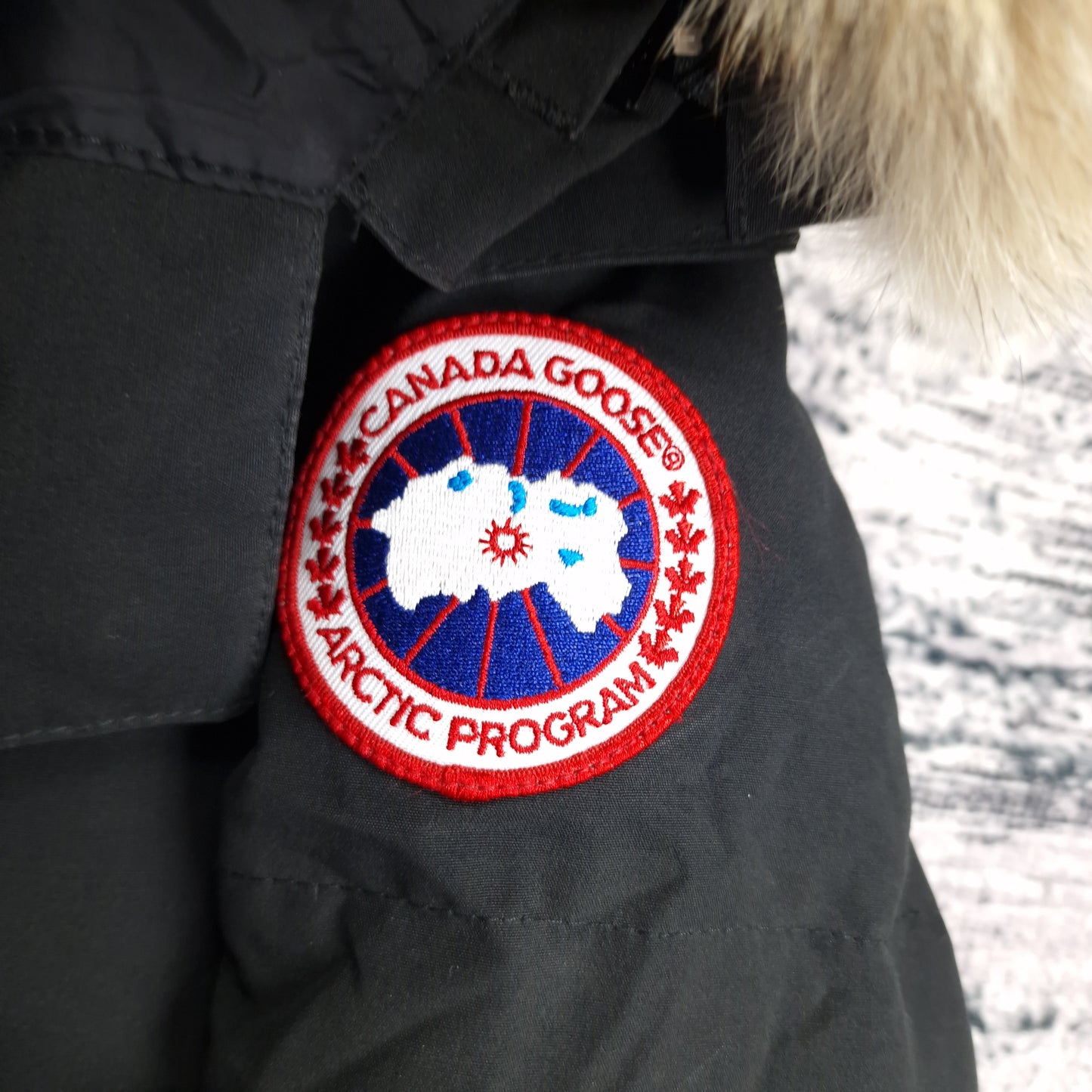 Close-up of authentic Canada Goose Arctic Program badge on Chelsea Parka 3804LA, black colorway Medium, showing iconic logo patch detail on women's luxury winter jacket