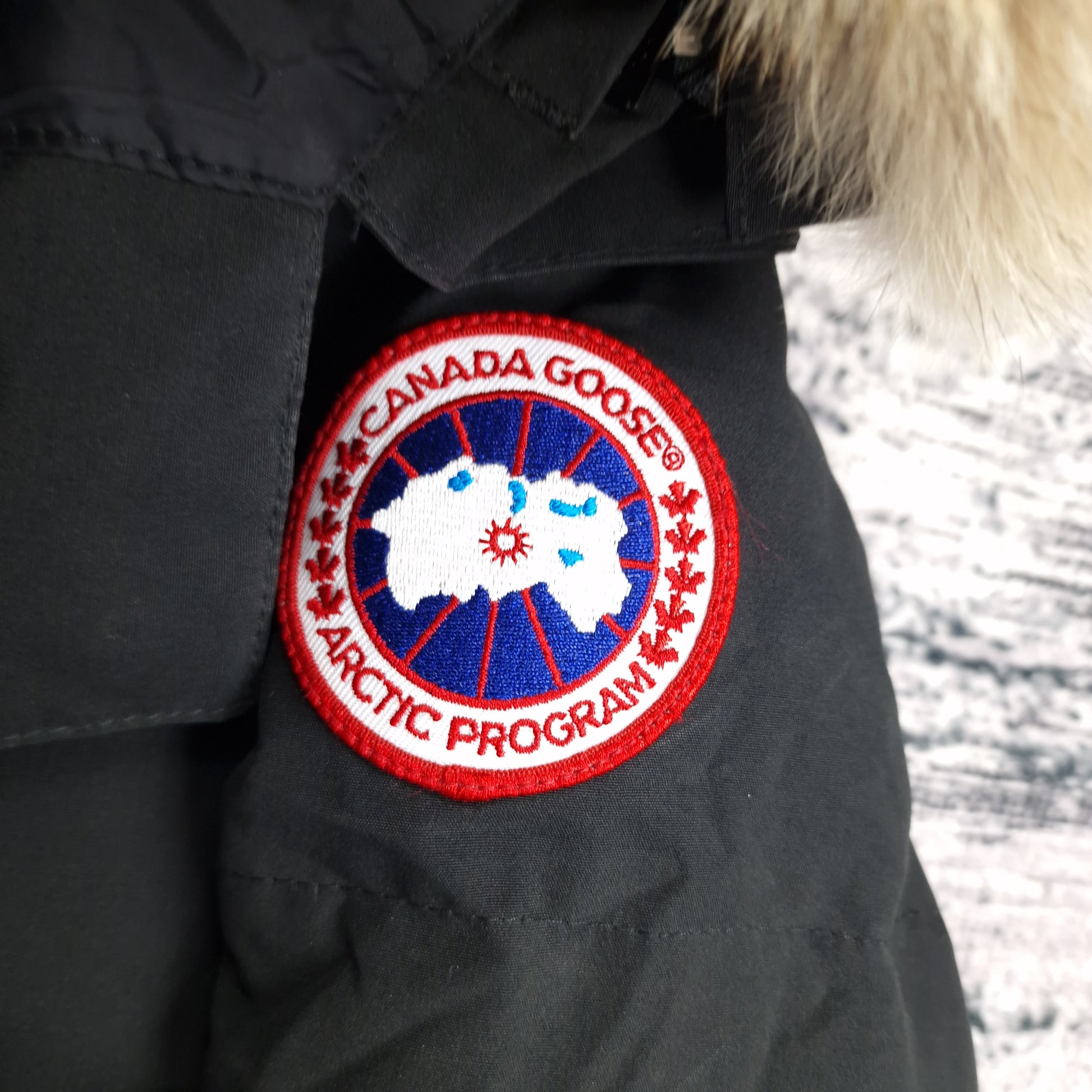 Close-up of authentic Canada Goose Arctic Program badge on Chelsea Parka 3804LA, black colorway Medium, showing iconic logo patch detail on women's luxury winter jacket