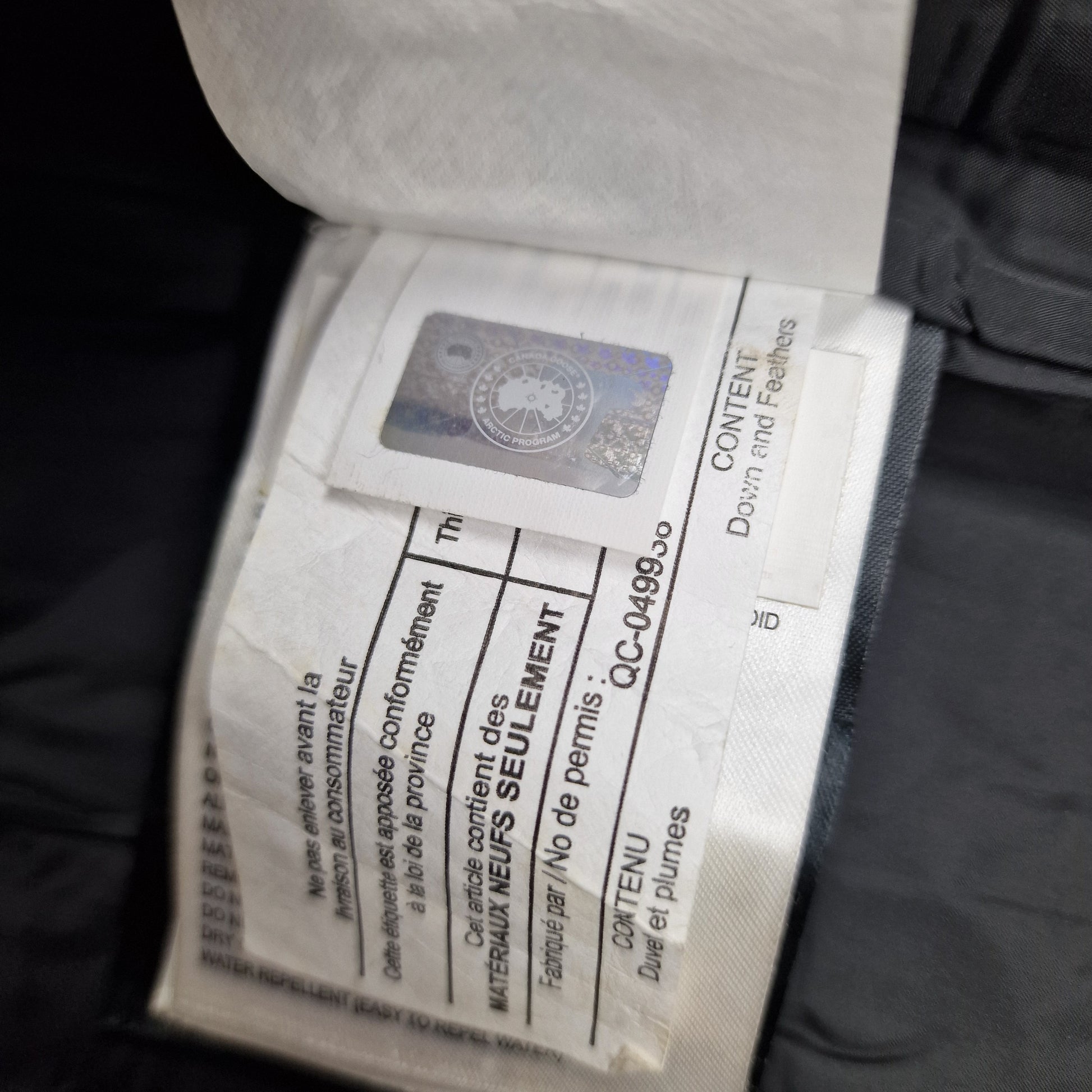 Close-up of Canada Goose authenticity hologram on Chelsea Parka 3804LA, verification label confirming genuine women's Medium black luxury winter coat