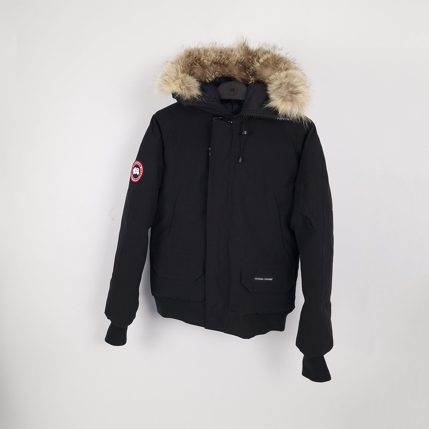 Professional product photo of Canada Goose Chilliwack Bomber in black, men's luxury down-filled bomber jacket with fur hood, style 7950M Small, full jacket view