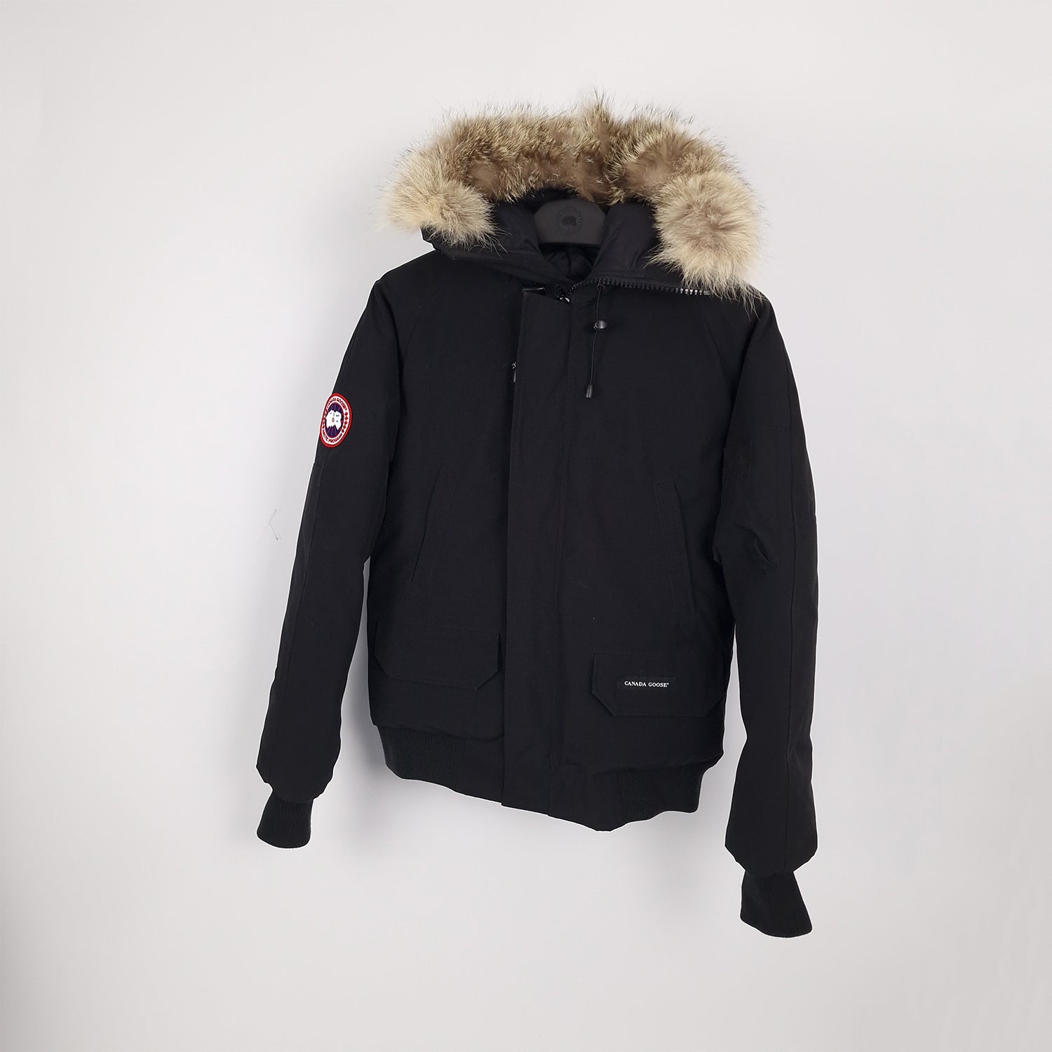 Professional product photo of Canada Goose Chilliwack Bomber in black, men's luxury down-filled bomber jacket with fur hood, style 7950M Small, full jacket view