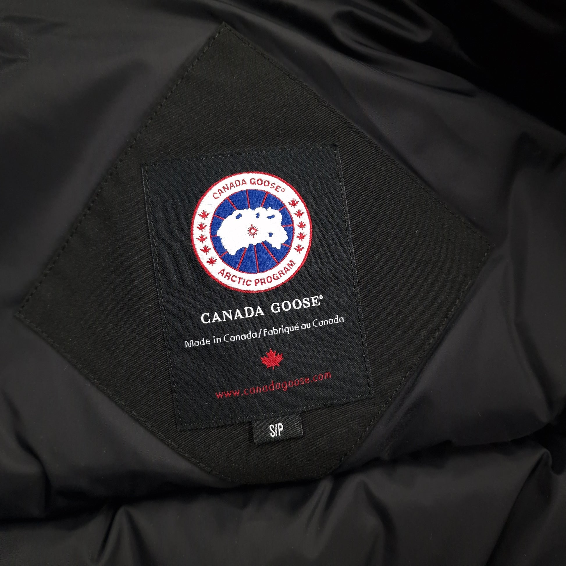 Close-up of Canada Goose necktag label inside Chilliwack Bomber 7950M, showing authentic branding and size Small details for men's black bomber jacket