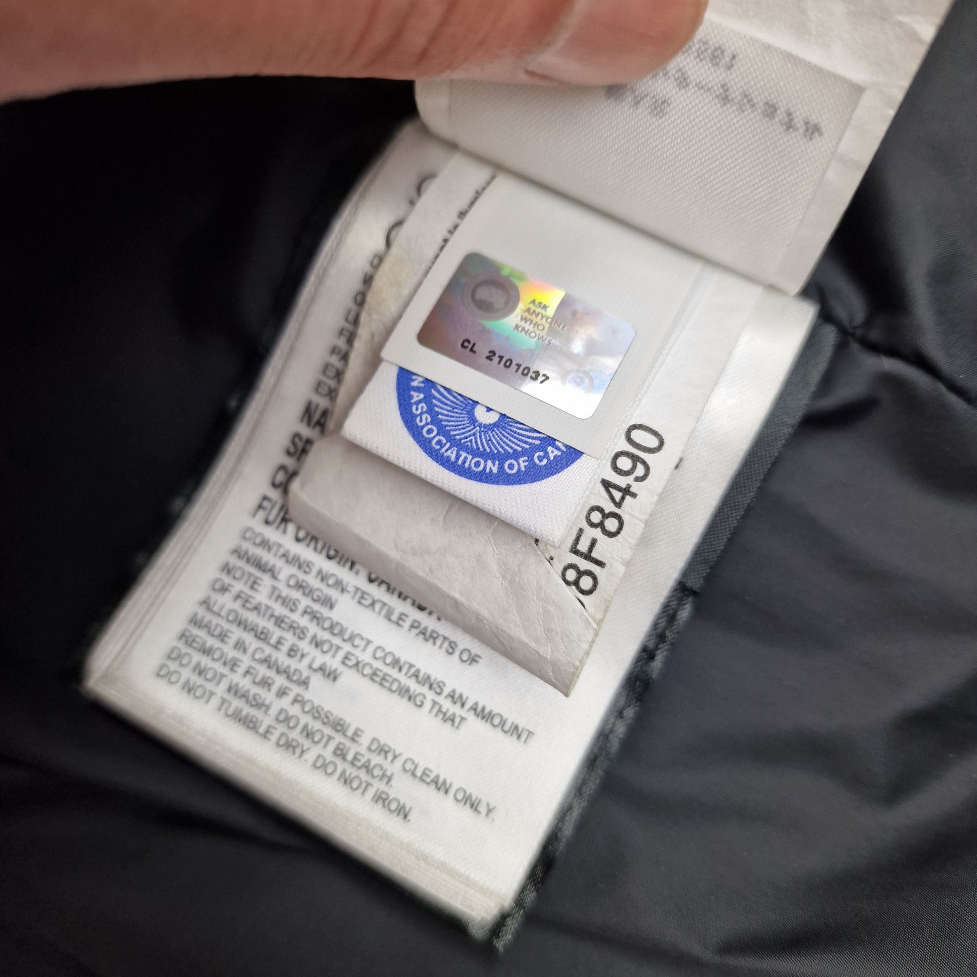 Close-up of Canada Goose authenticity hologram on Mackenzie Parka, verification for genuine women's Medium Graphite grey coat, Shelburne Parka comparable luxury winter jacket