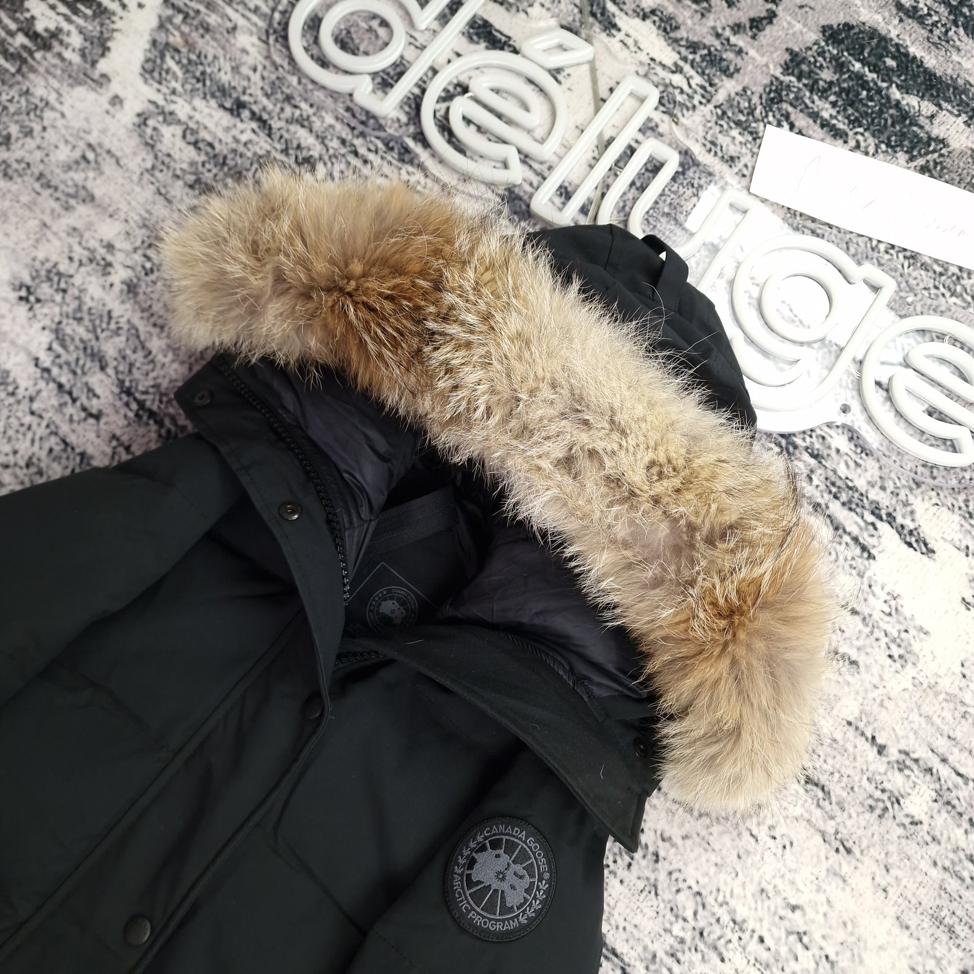 Close-up side view of Canada Goose Shelburne Parka Black Label showing authentic coyote fur hood trim and iconic Canada Goose Arctic Program badge, black colorway 3802LB Small