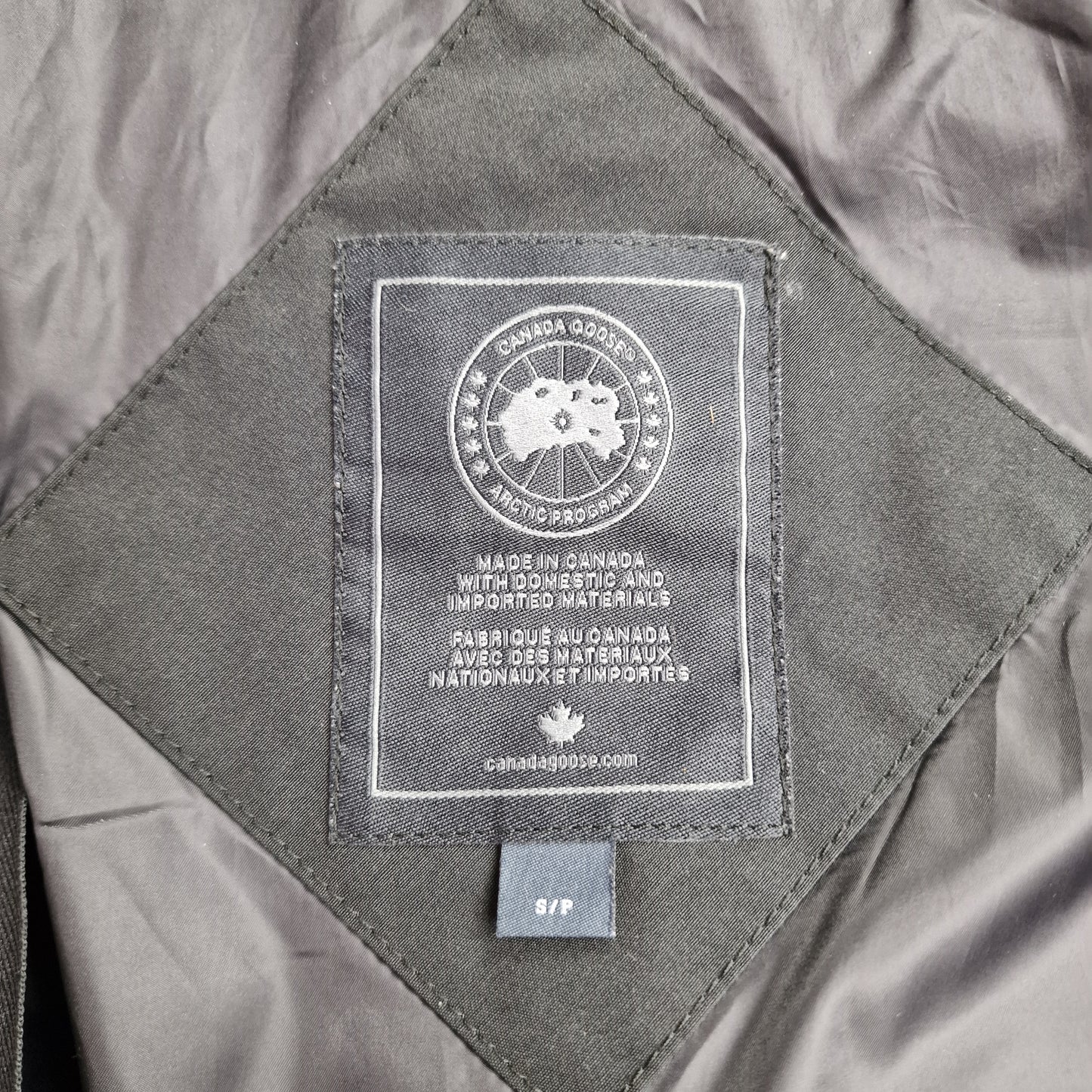 Close-up of Canada Goose necktag label inside Shelburne Parka Black Label 3802LB, showing authentic branding and size Small details for women's black winter jacket