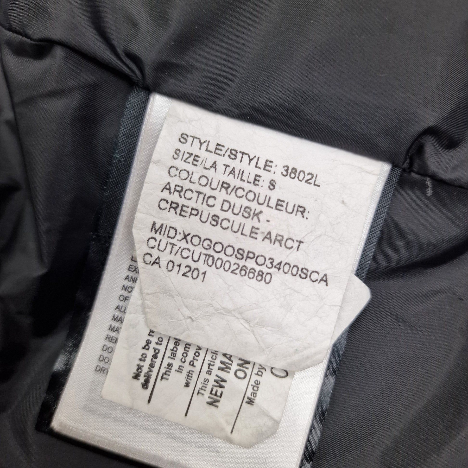 White care label washtag showing style code 3802L, Purple Arctic Disk color designation, and size information for authentic Canada Goose Shelburne Parka women's winter jacket