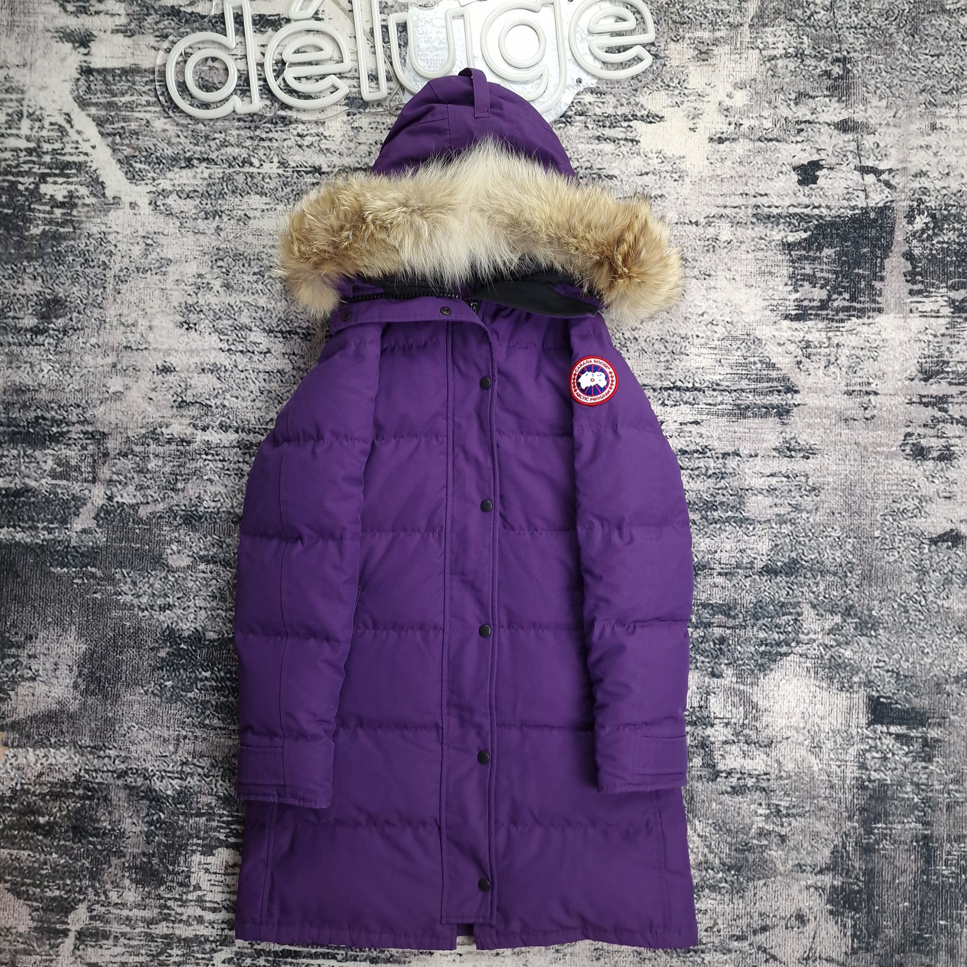 Front view of women's Canada Goose Shelburne Parka 3802L in rare Purple Arctic Disk colorway with coyote fur-trimmed hood, luxury winter coat photographed on styled background