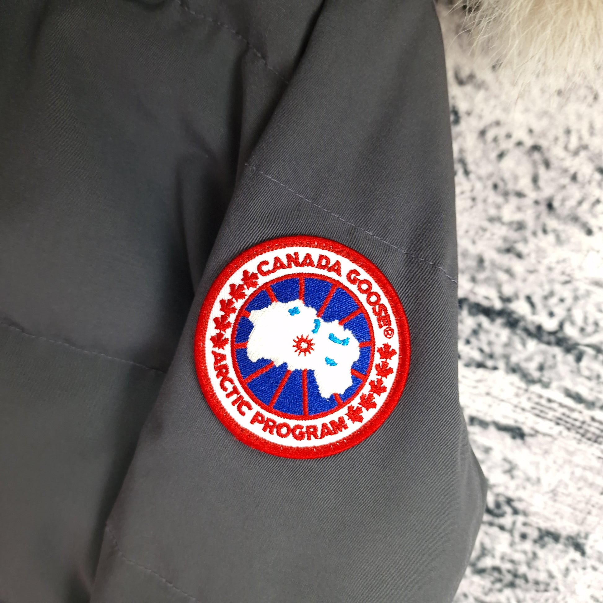 Close-up of authentic Canada Goose Arctic Program badge on Mackenzie Parka, Graphite grey Medium, similar quality to Shelburne Parka women's luxury winter jacket