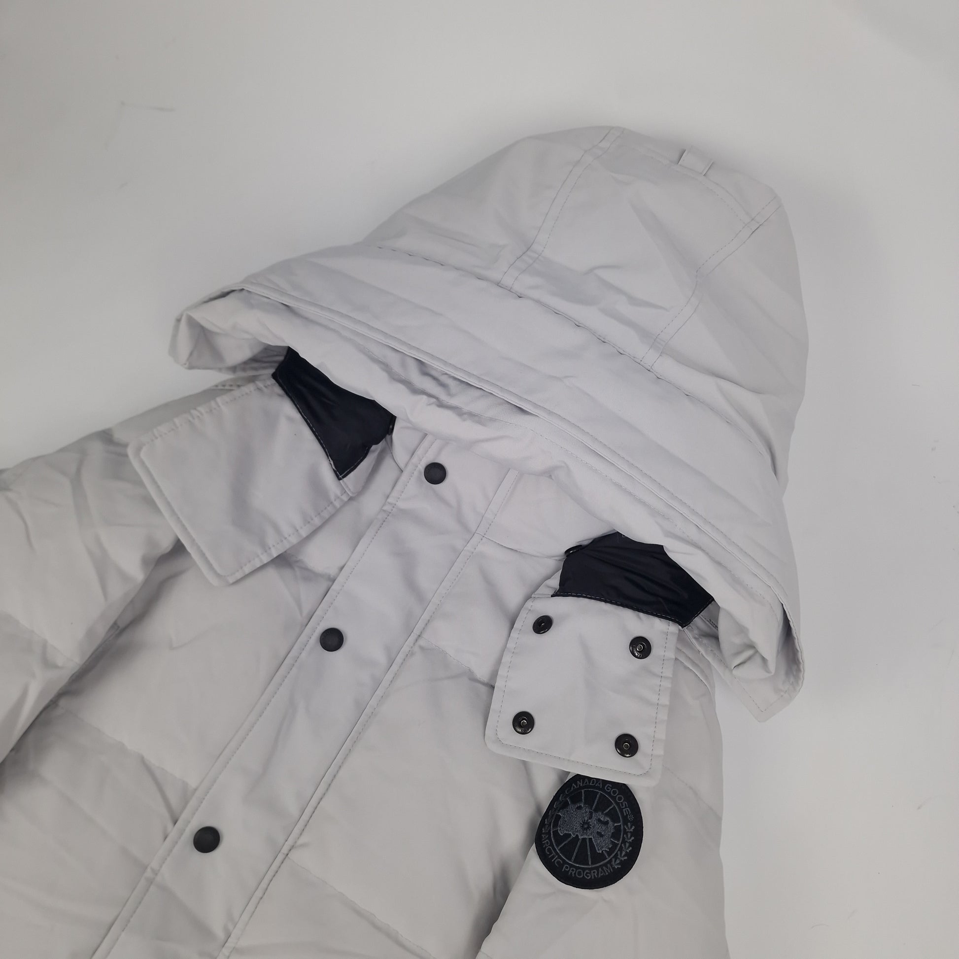 Close-up side view of Canada Goose Wyndham Parka Black Label showing authentic coyote fur hood trim and iconic Canada Goose Arctic Program badge, Silverbirch colorway 3808MB Medium