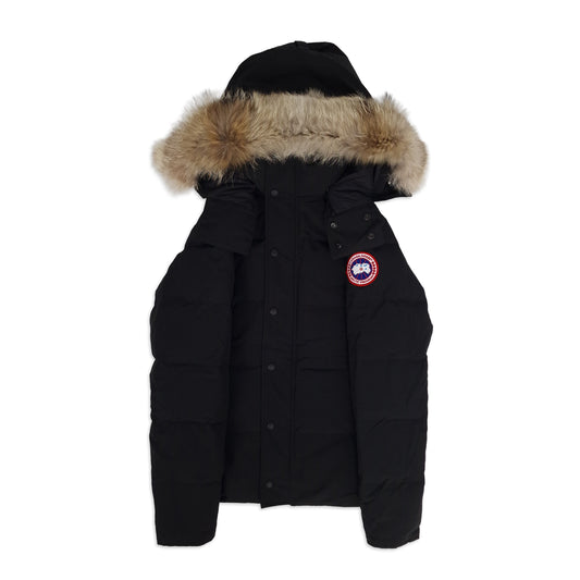 Front view of men's Canada Goose Wyndham Parka 3808MA size XS in classic black with coyote fur-trimmed hood, displayed on white background