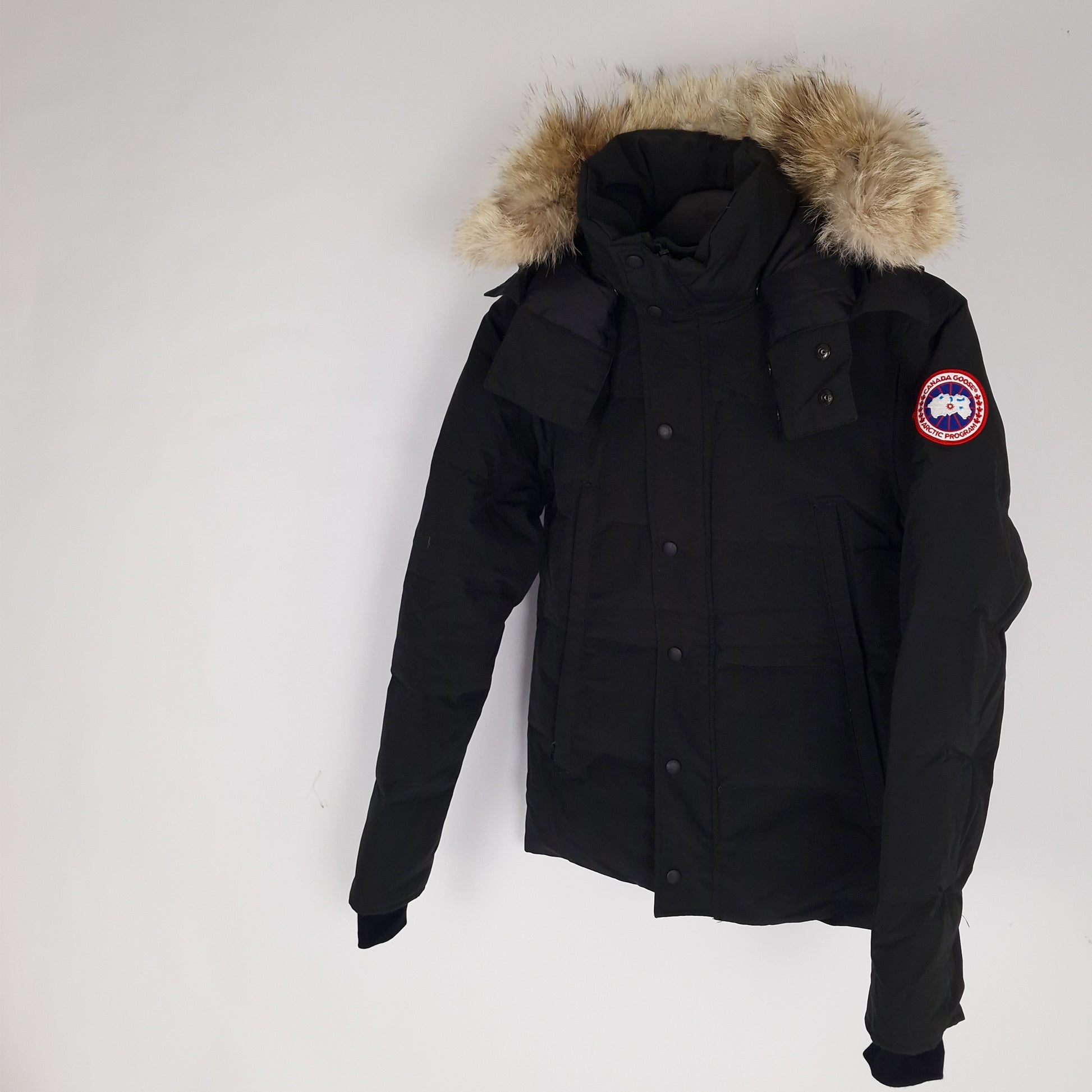 Professional product photo of Canada Goose Wyndham Parka in black, men's luxury down-filled winter coat with fur hood, style 3808MA XS, full jacket view