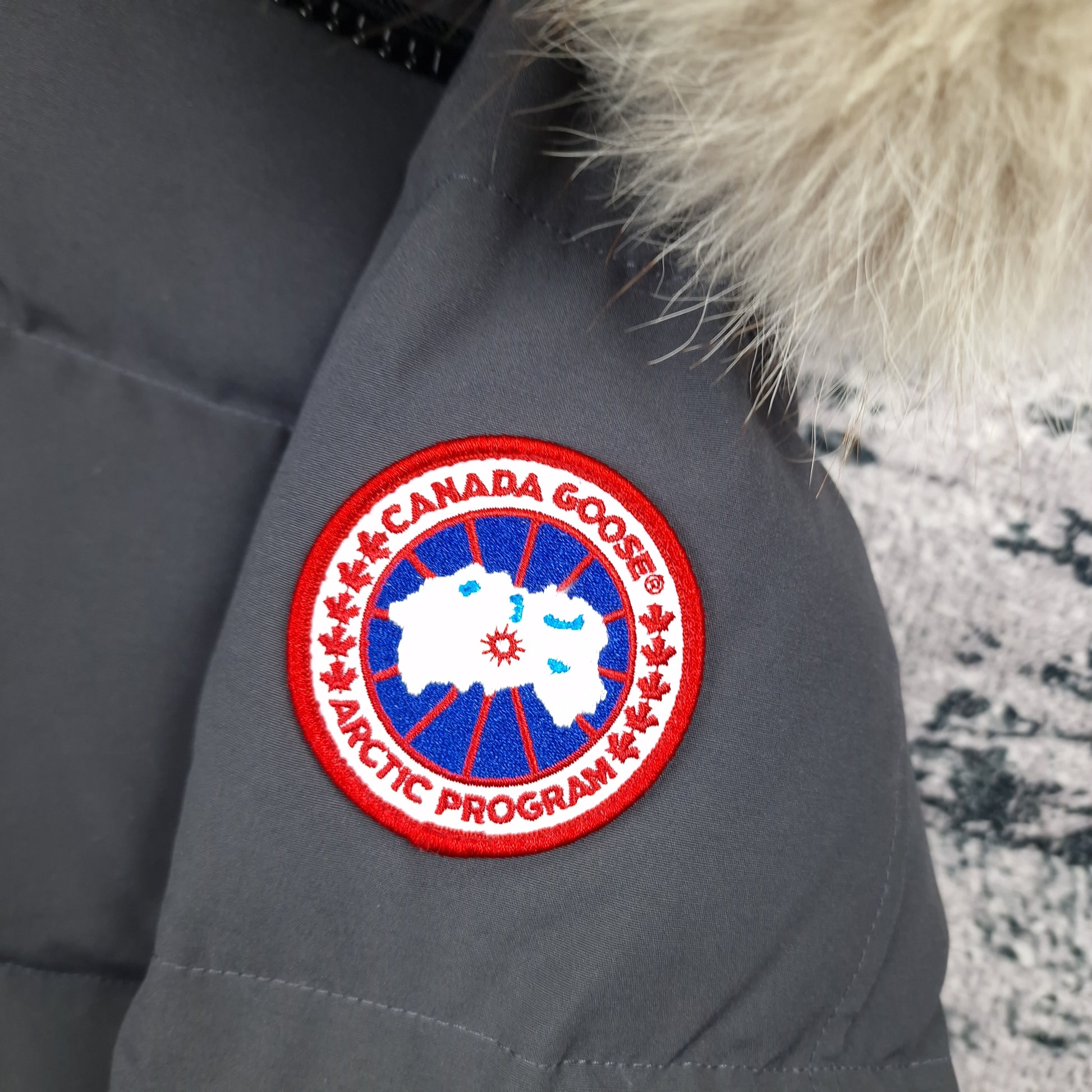 Close-up of authentic Canada Goose Arctic Program badge on Wyndham Parka 3808MA, Graphite grey colorway XS, showing iconic logo patch detail on men's luxury winter jacket