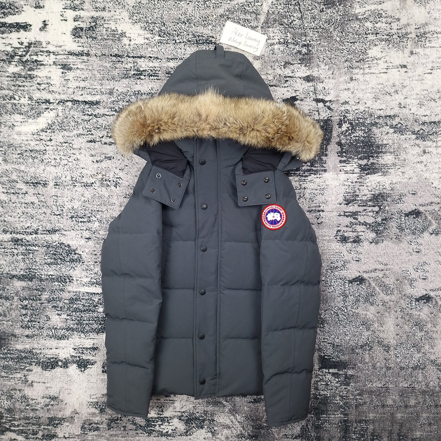 Front view of men's Canada Goose Wyndham Parka 3808MA XS in Graphite grey with coyote fur-trimmed hood, luxury winter coat photographed on styled background