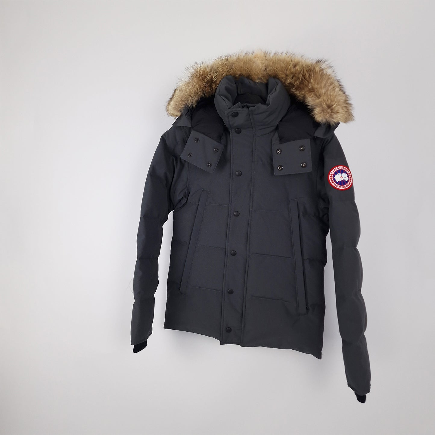 Professional product photo of Canada Goose Wyndham Parka in Graphite grey, men's luxury down-filled winter coat with fur hood, style 3808MA XS, full jacket view