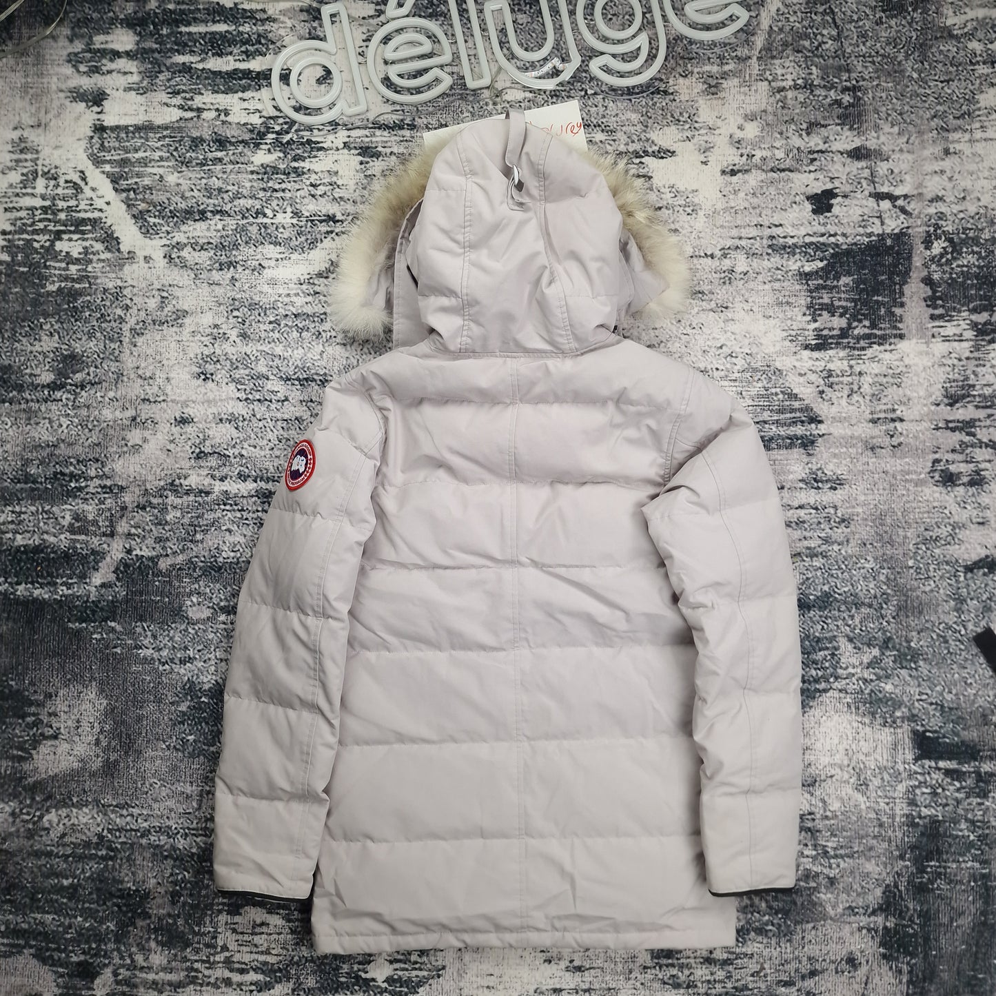 Back flat lay of Canada Goose Carson Parka 3805M men's small in limestone with coyote fur-trimmed hood and thigh-length design