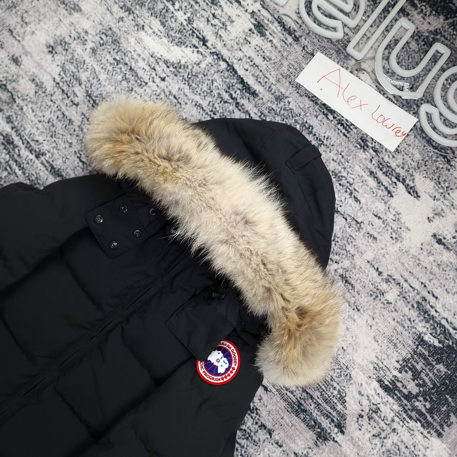 Close-up flat lay of Canada Goose Chelsea Parka 3804LA showing luxurious coyote fur hood trim and Arctic Program disc badge