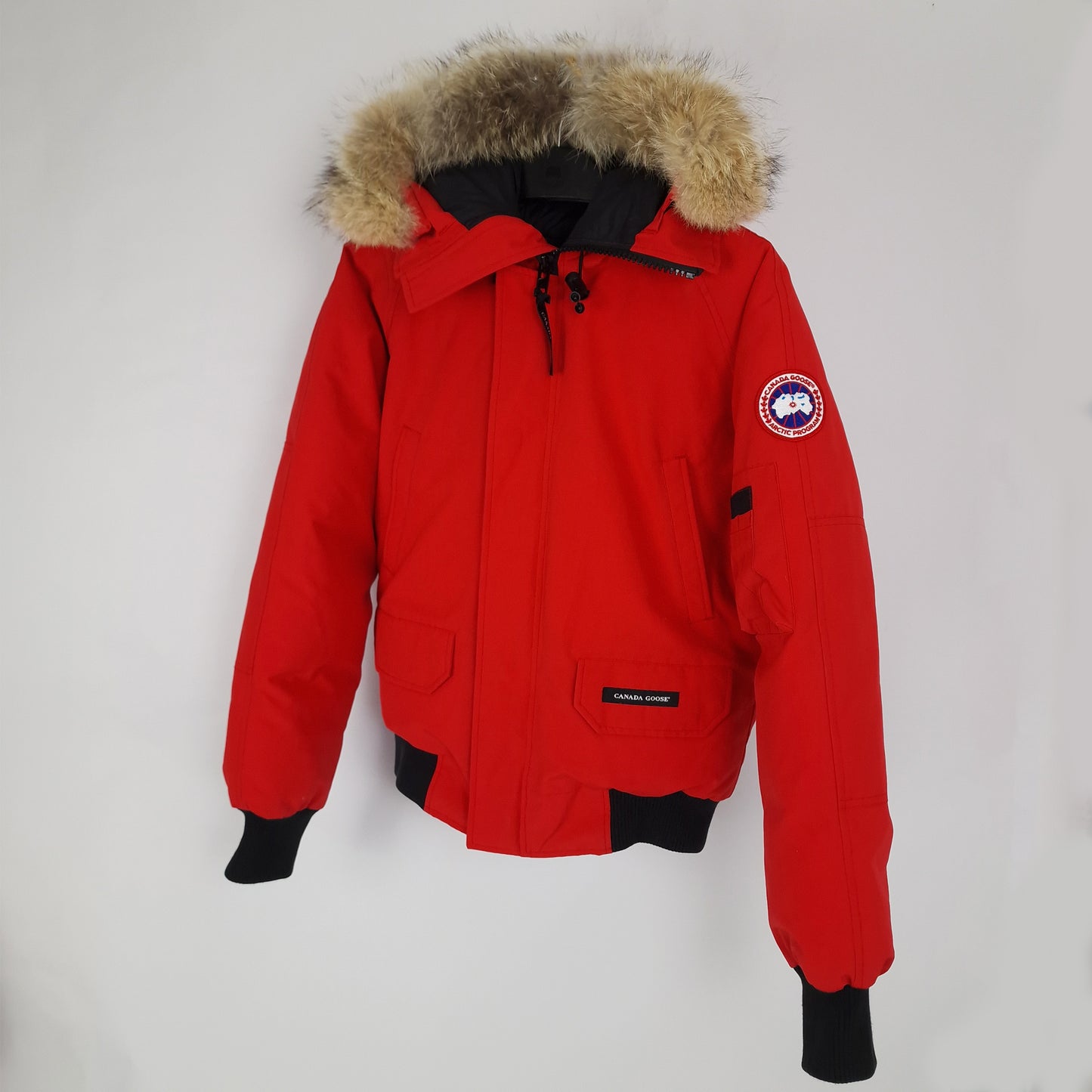Front angled view of red Canada Goose Chilliwack bomber jacket size small displaying fur hood, front pockets, and sleeve badge