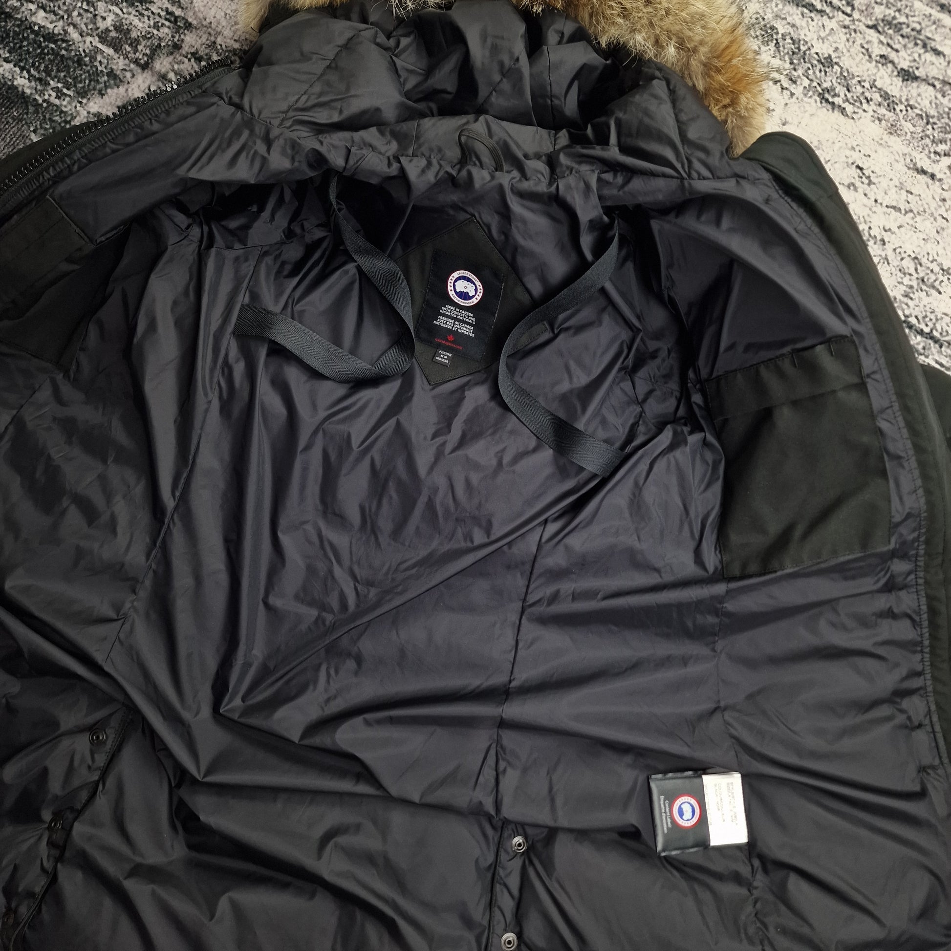 Interior view of black Canada Goose Lorette Parka women's medium showing black lining and authentic interior tags
