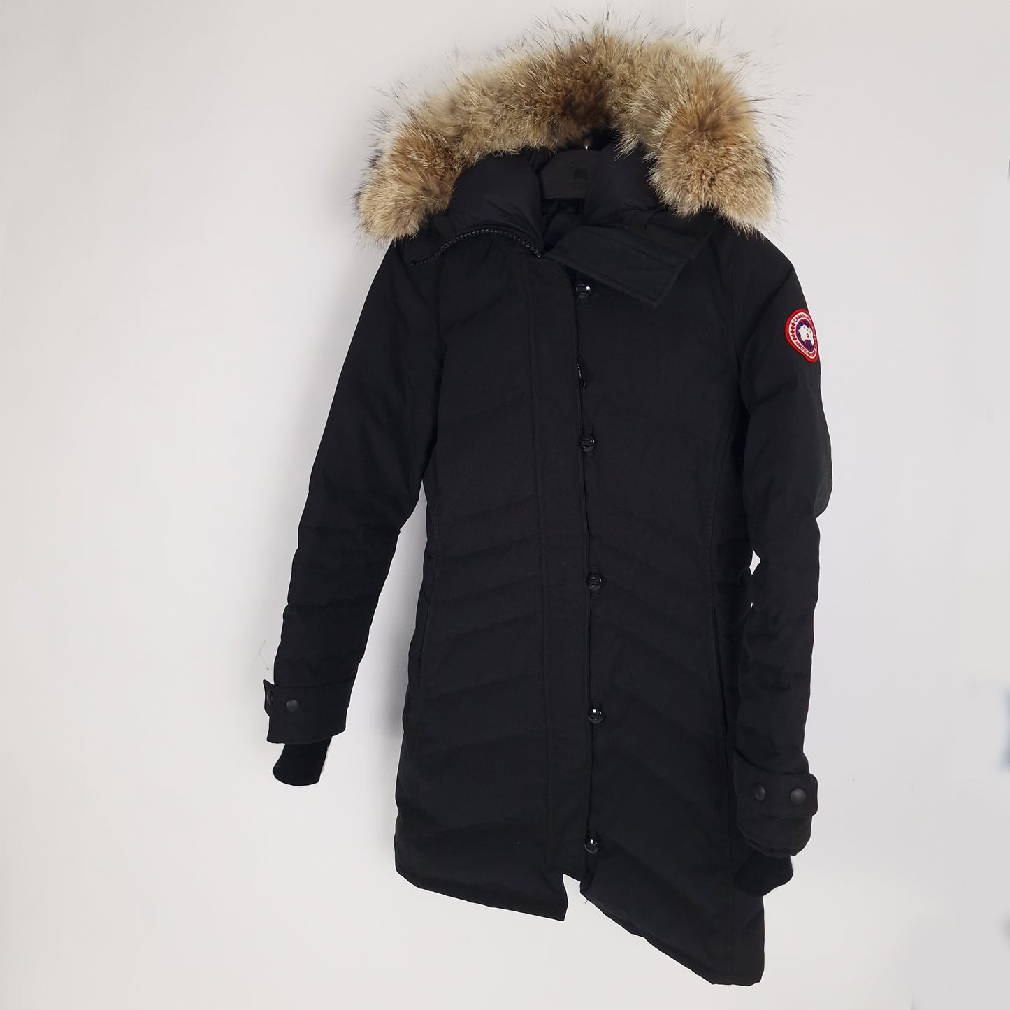 Side angled view of black Canada Goose Lorette Parka women's size medium displaying tailored fit and coyote fur hood trim