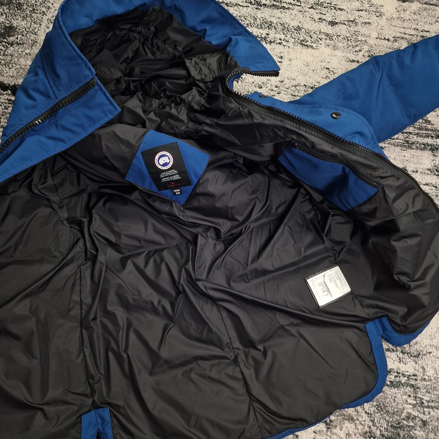 Interior view of Canada Goose Macmillan Parka Northern Night blue medium showing black lining, authentic tags, and zipper detail