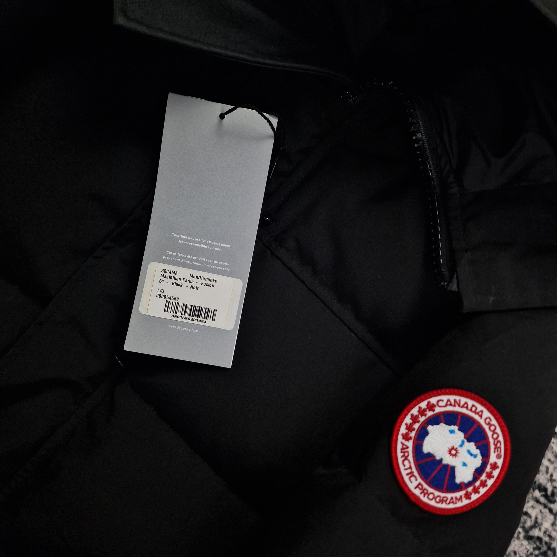 Close-up of authentic Canada Goose hang tag on Macmillan Parka 3804MA showing size large and product specifications