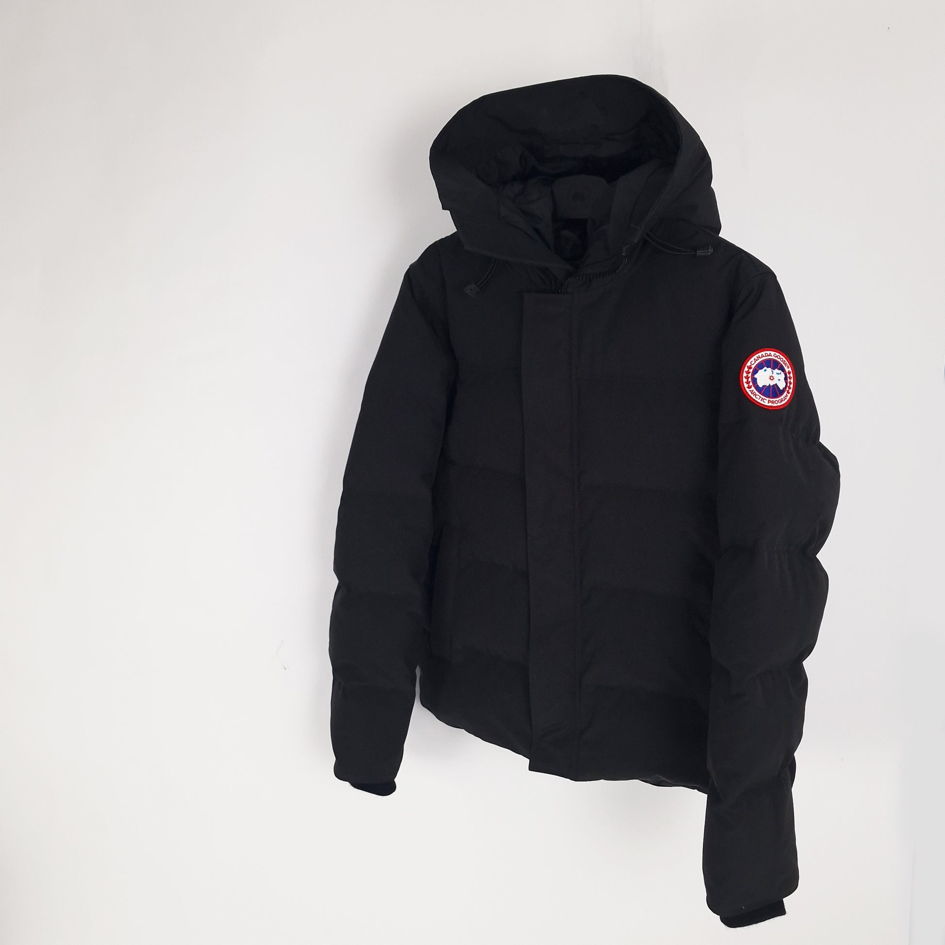 Angled view of black Canada Goose Macmillan Parka 3804MA men's large showing ribbed cuffs and Arctic Program badge