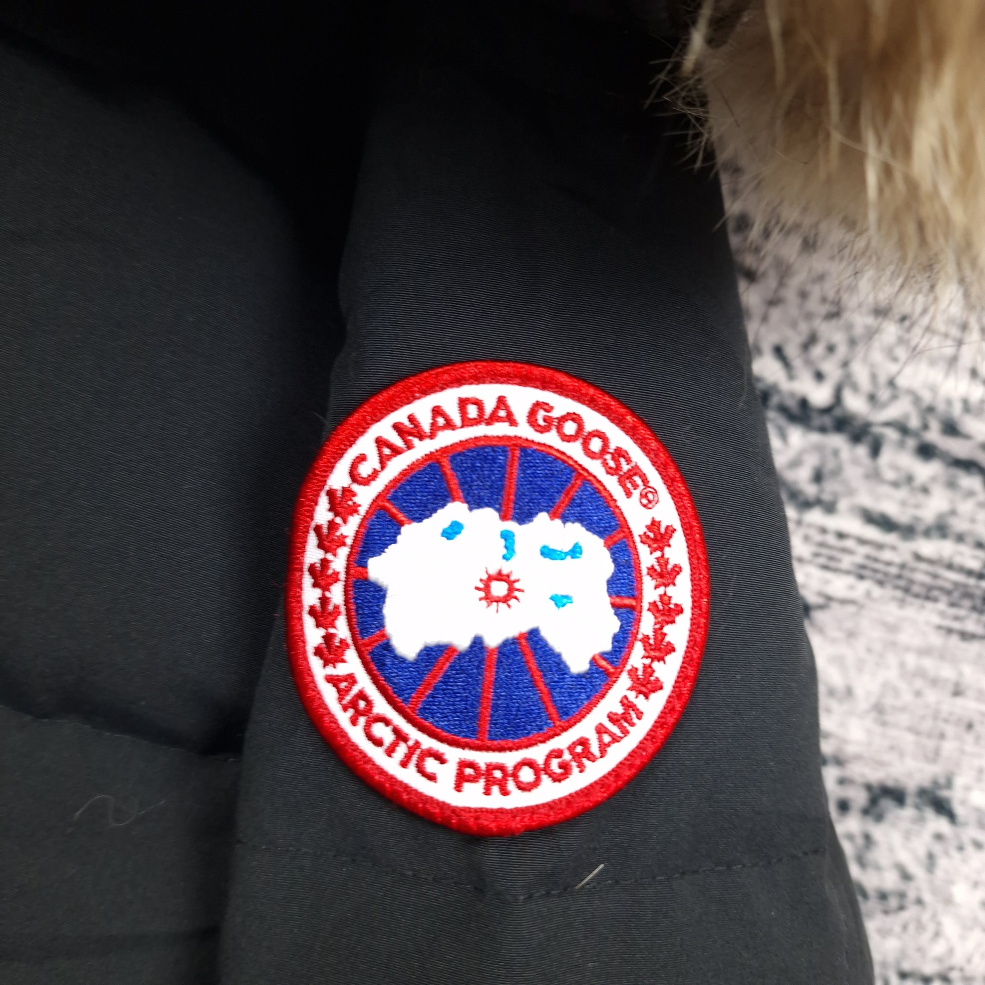 Detailed close-up of authentic Canada Goose Arctic Program patch on Heritage Black Shelburne Parka 3802LA women's small sleeve