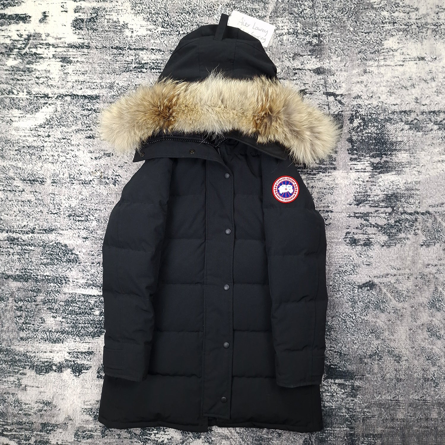 Front flat lay of black Canada Goose Shelburne Parka women's small with coyote fur hood trim and Arctic Program disc badge