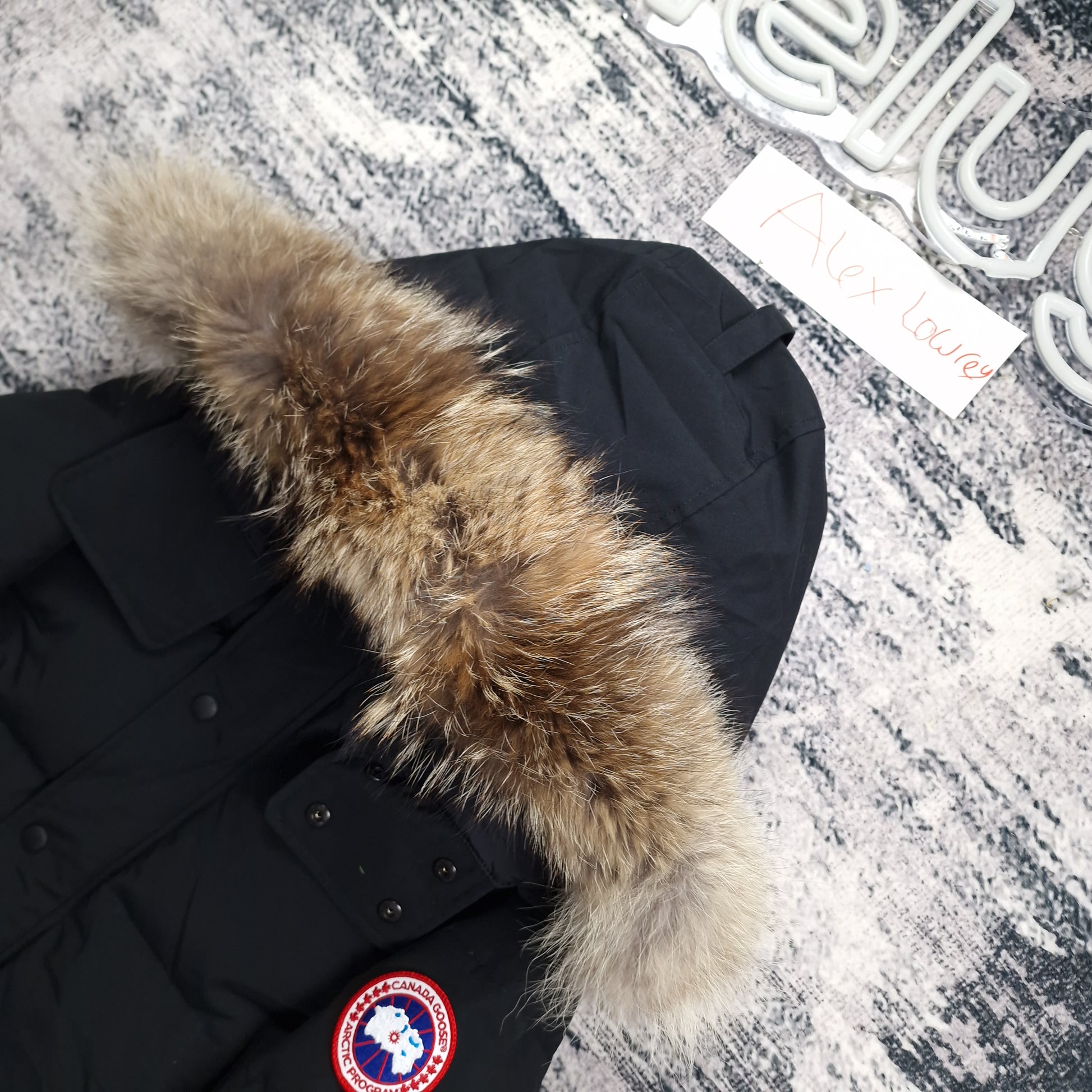 Close-up of Canada Goose Wyndham Heritage parka 3808MA men's large in black, showcasing premium coyote fur hood trim and signature Arctic Program badge