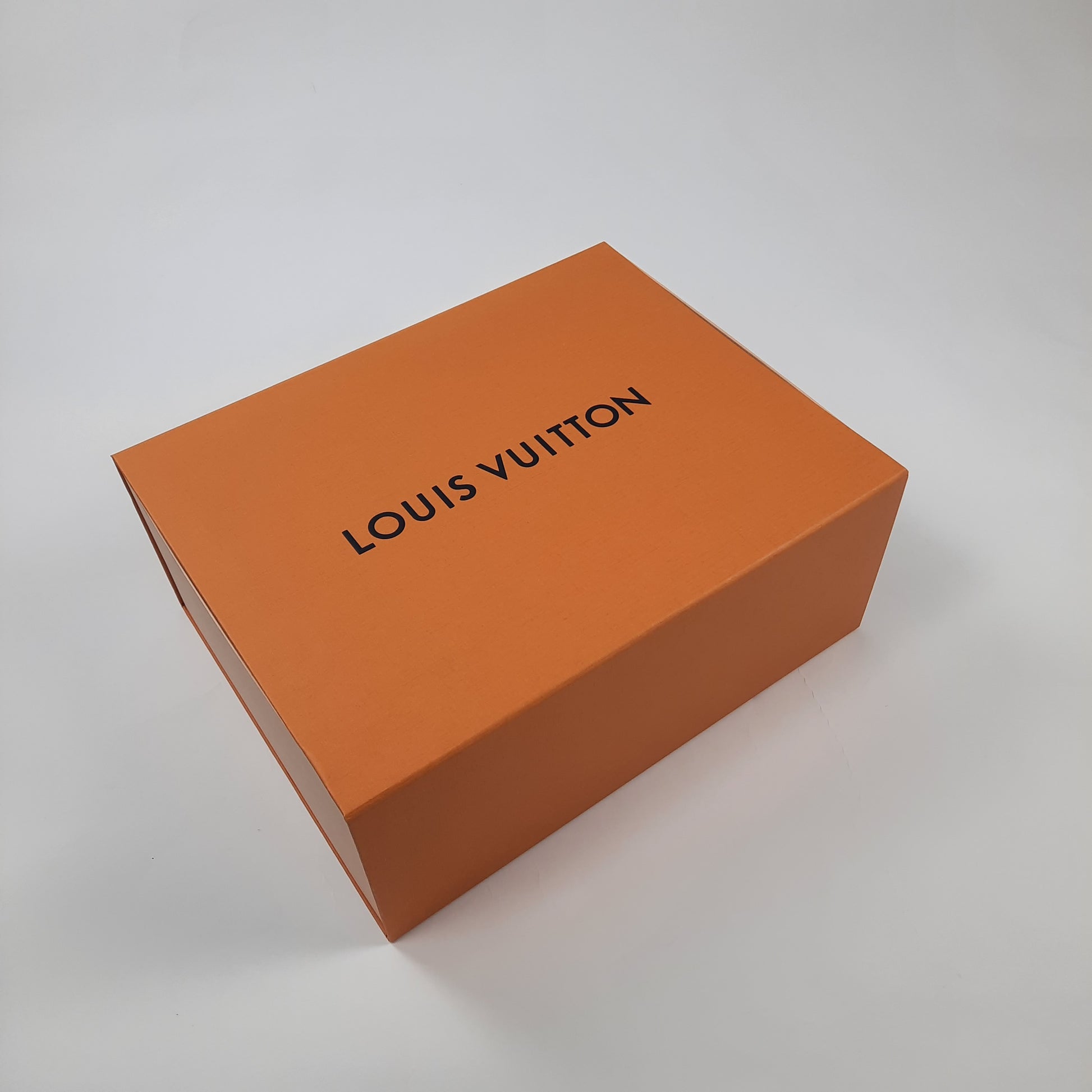 Authentic Louis Vuitton orange shoe box with black logo lettering, luxury designer sneaker packaging for LV Trainer