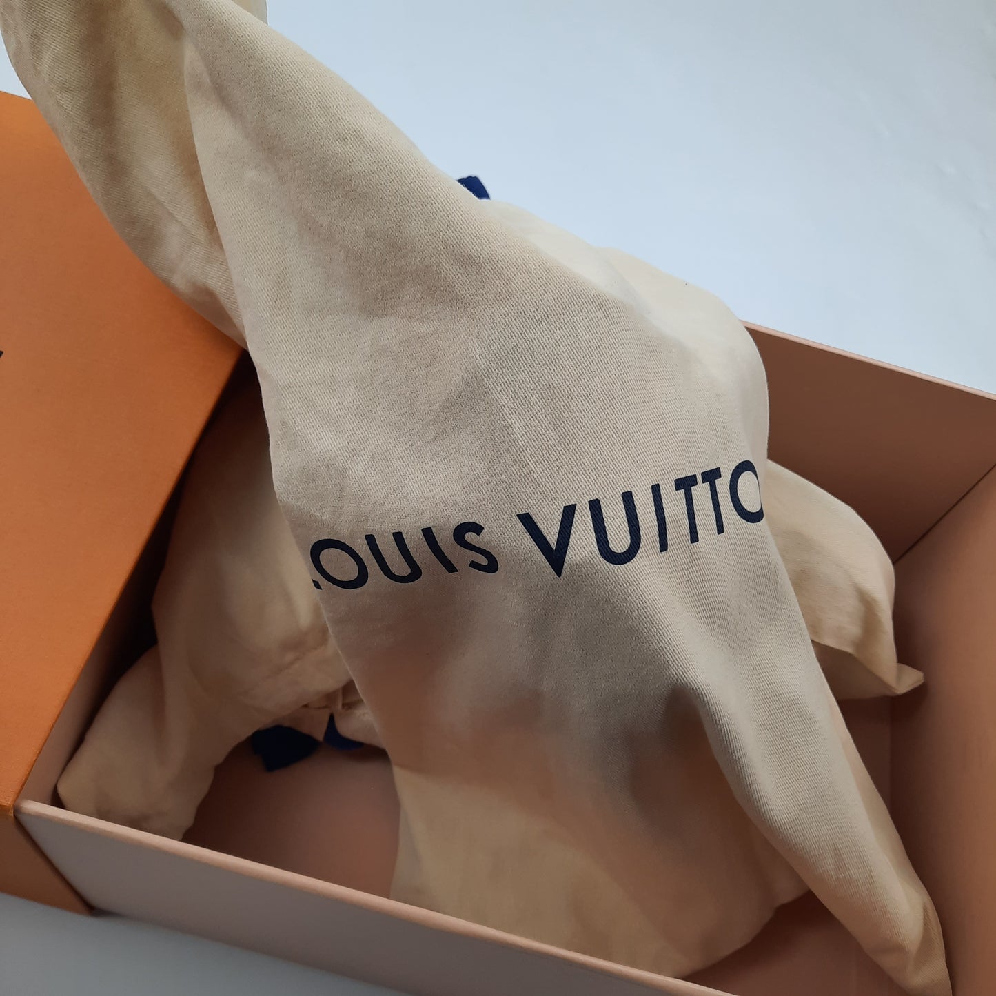 Louis Vuitton cream dust bag with logo inside orange box, luxury storage for LV Trainer sneakers size 8